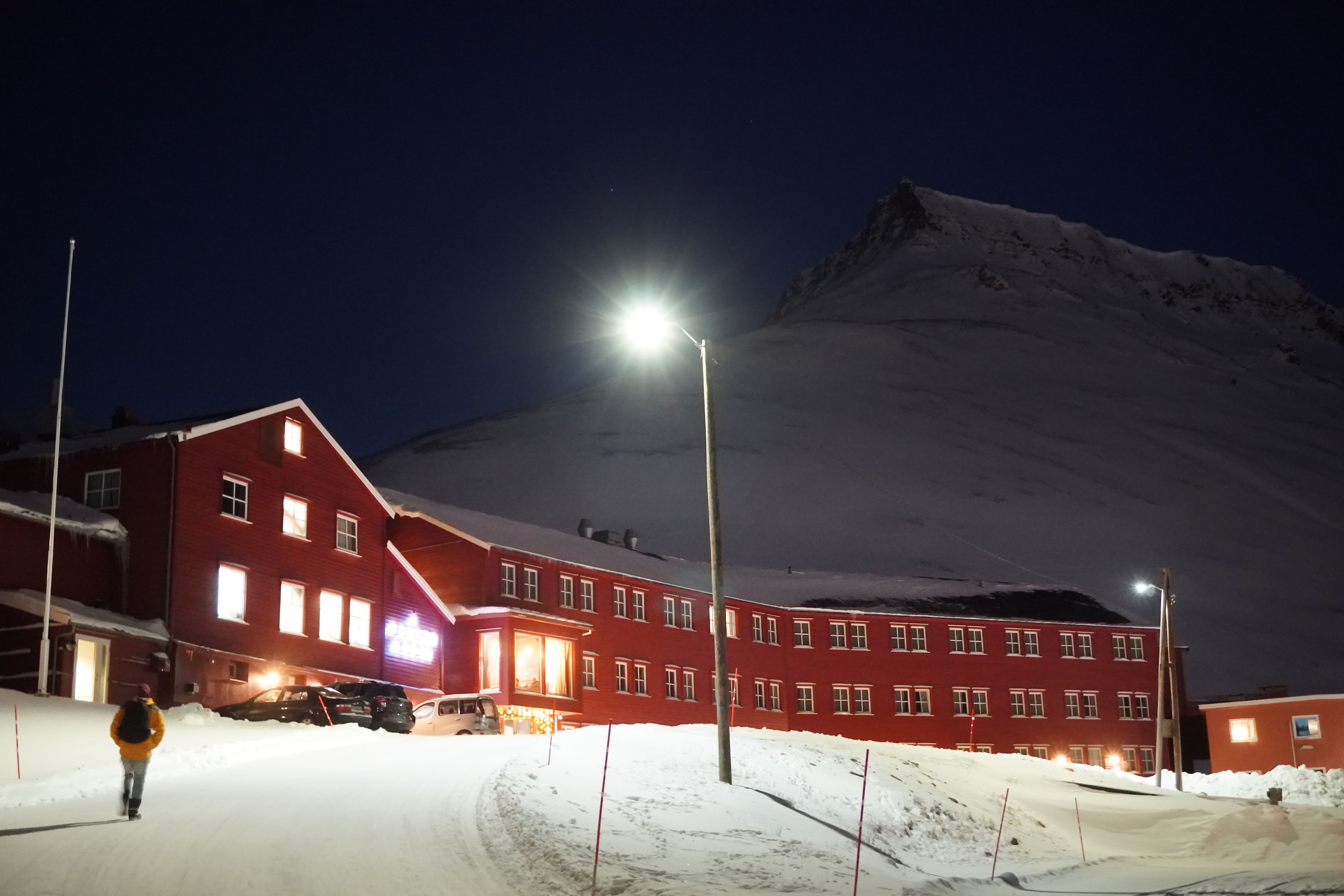 Et rødt hus foran et fjell i Longyearbyen