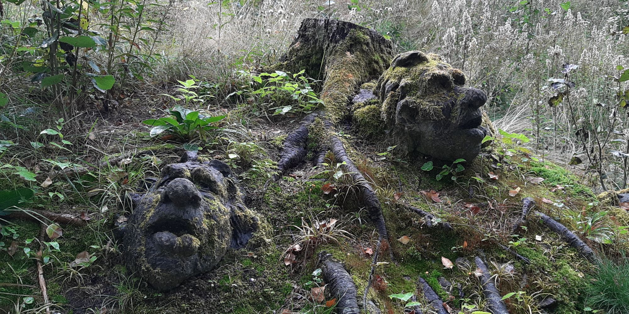 Two troll faces carved in wood