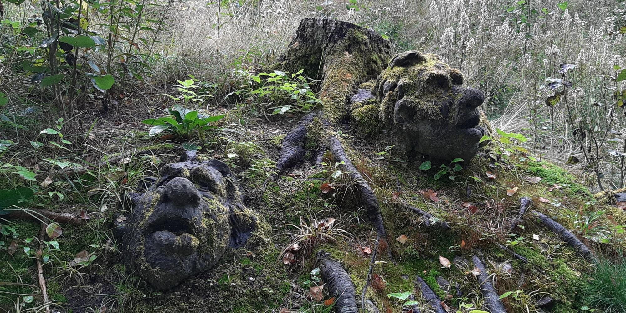 Two troll faces carved in wood