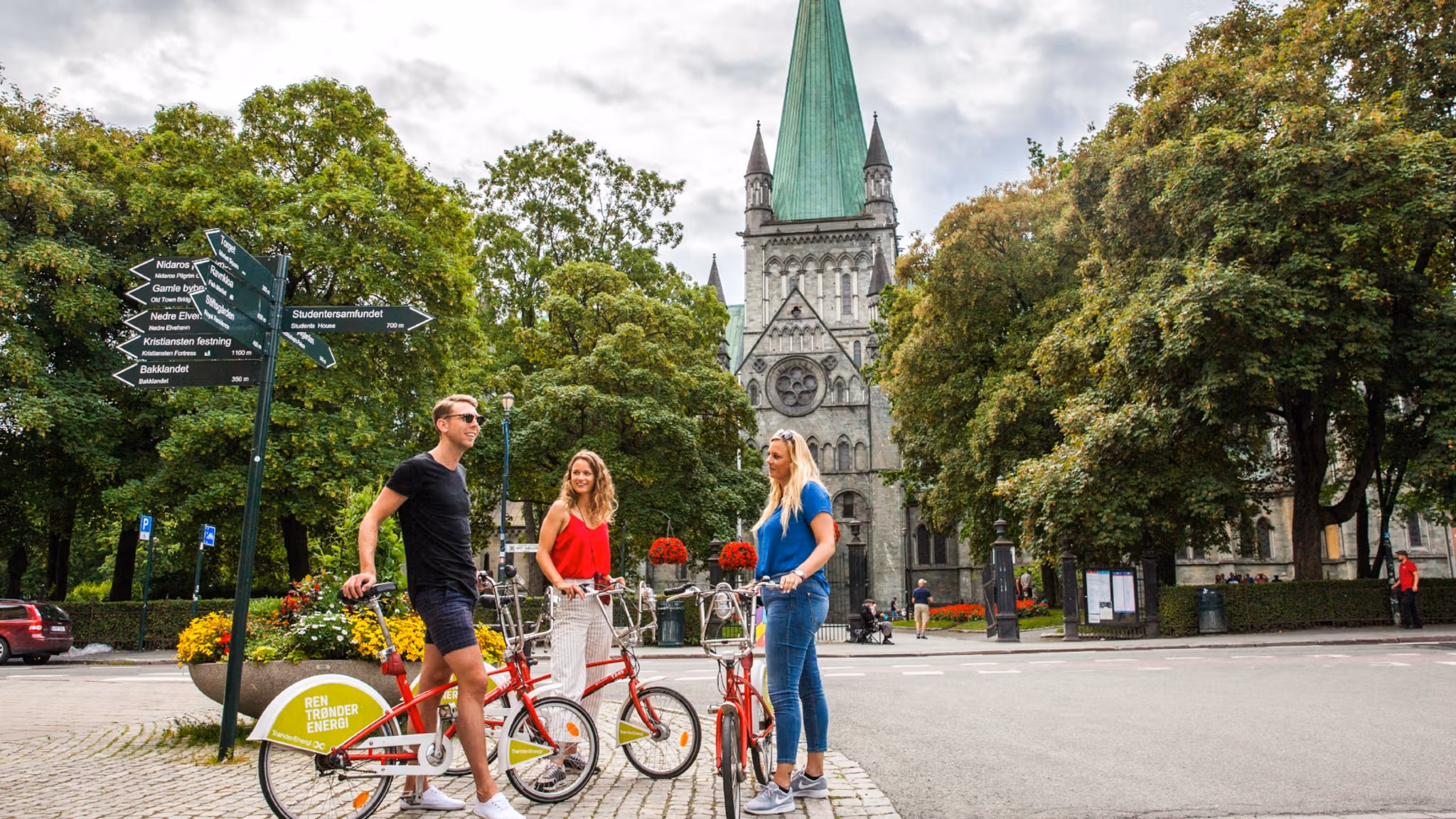 Tre personer med cyklar på besök i Trondheim, Norge