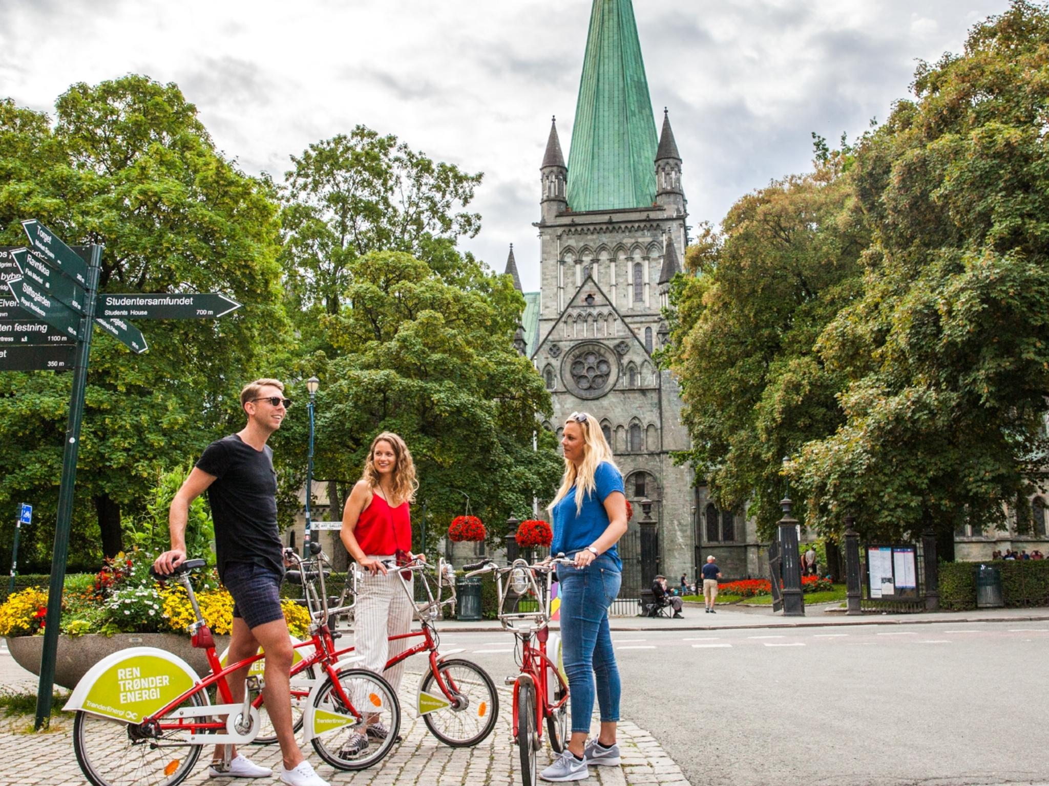 Three people with bikes on a city break in Trondheim, Norway