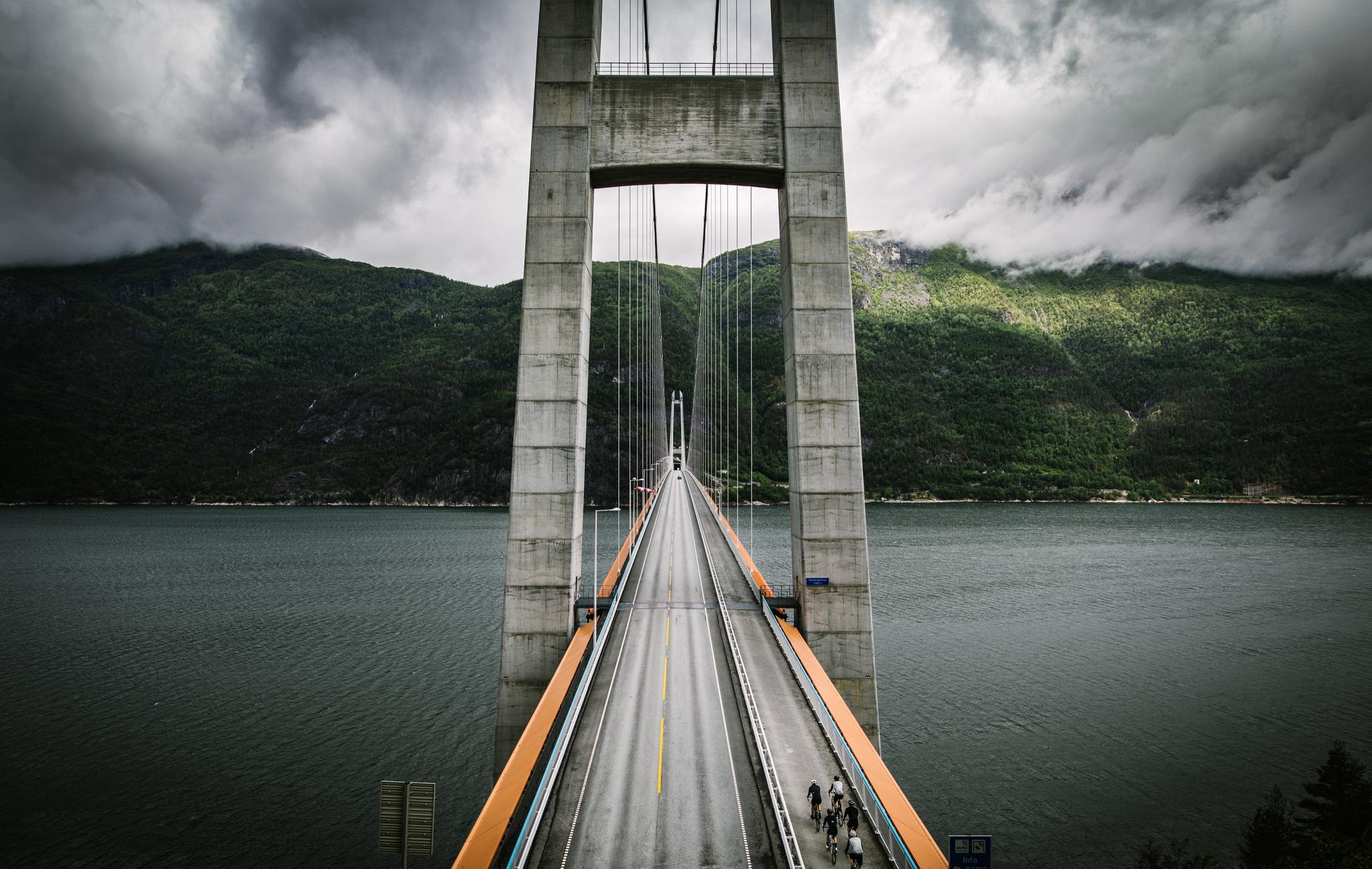 A group of road cyclists crossing a bridge in Fjord Norway