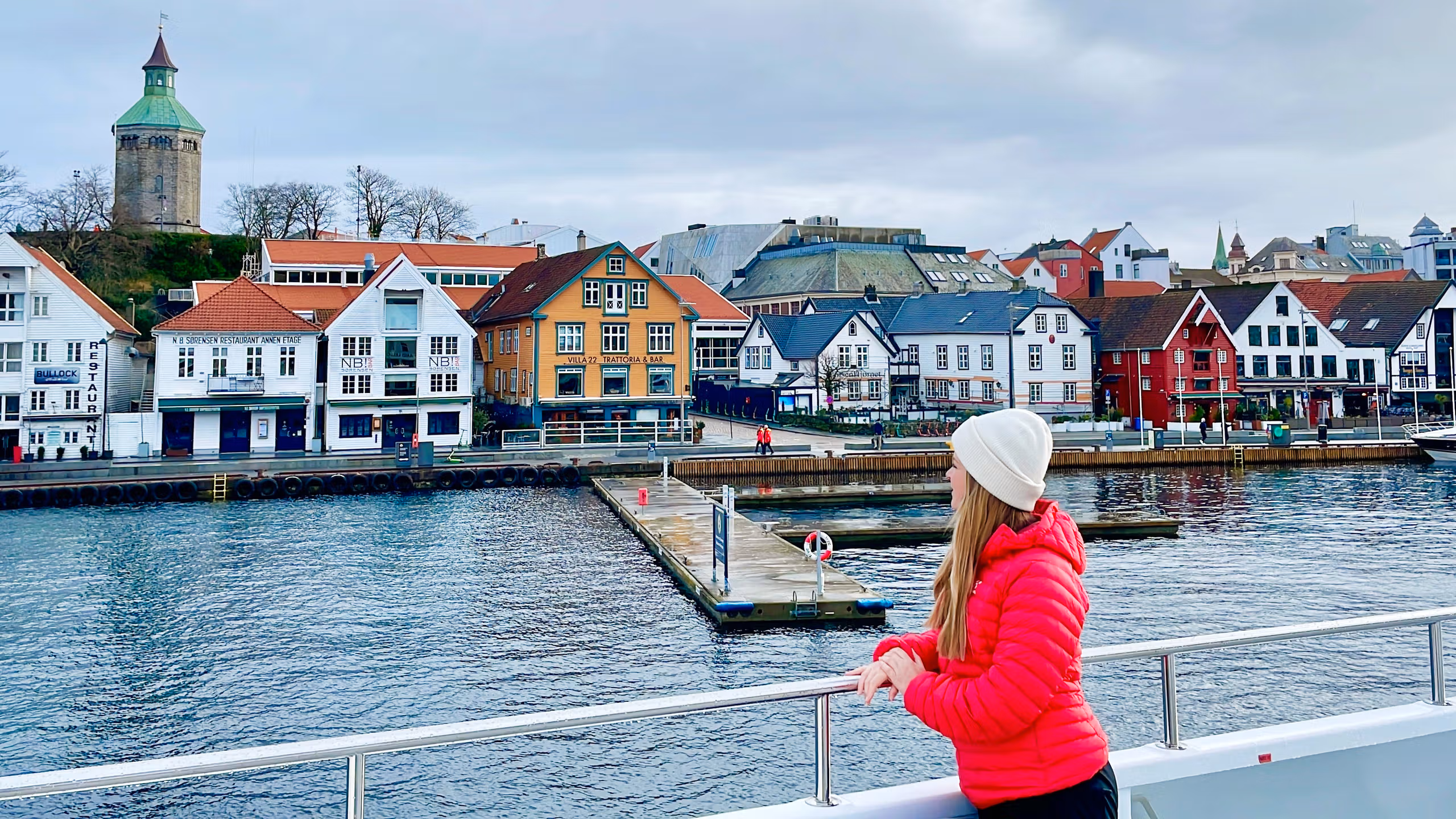A woman standing on a cruise ship with view to the harbour of Stavanger