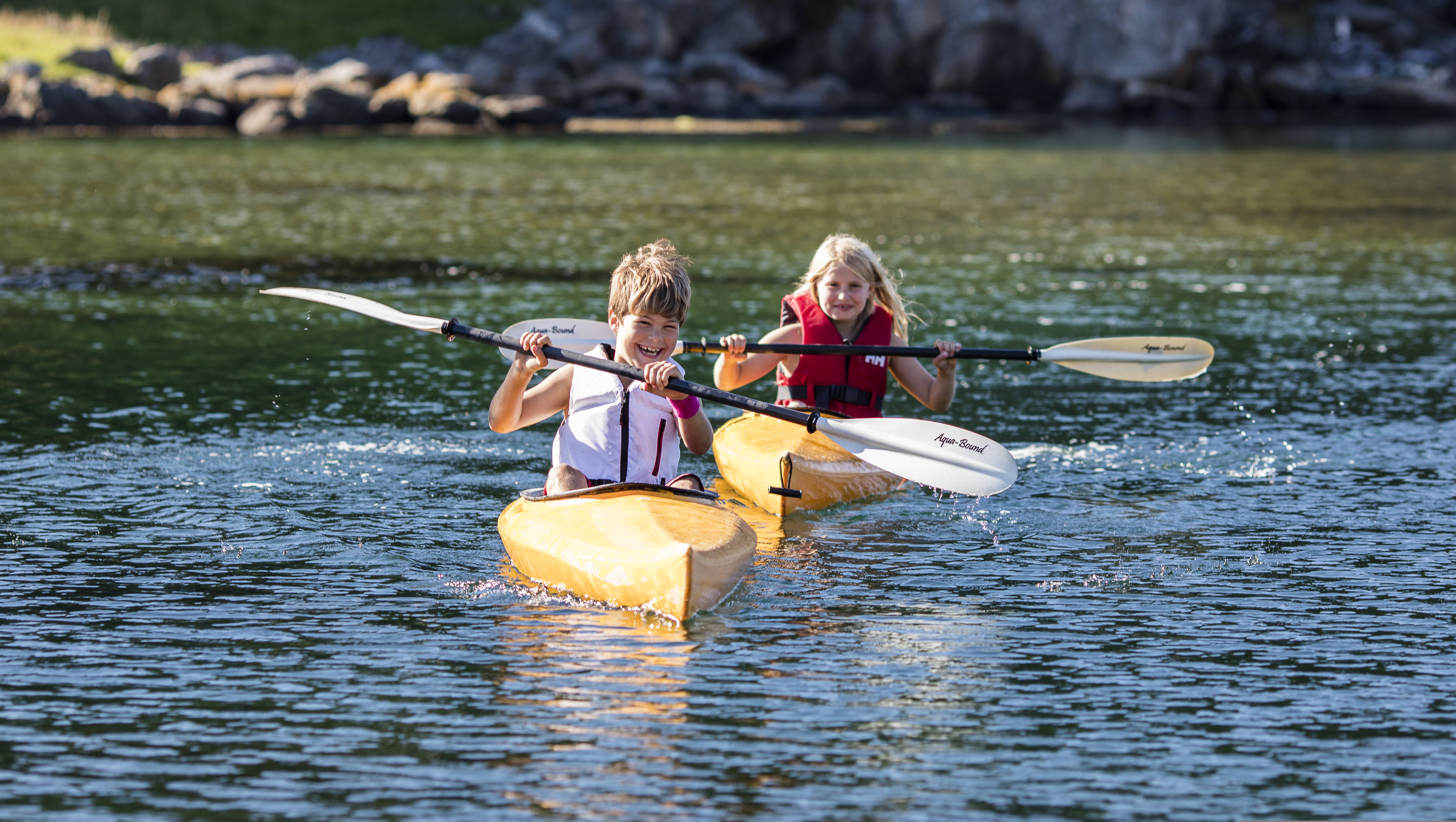 Two children are kayaking in the waters by the island Hidra outside Flekkefjord in Southern Norway