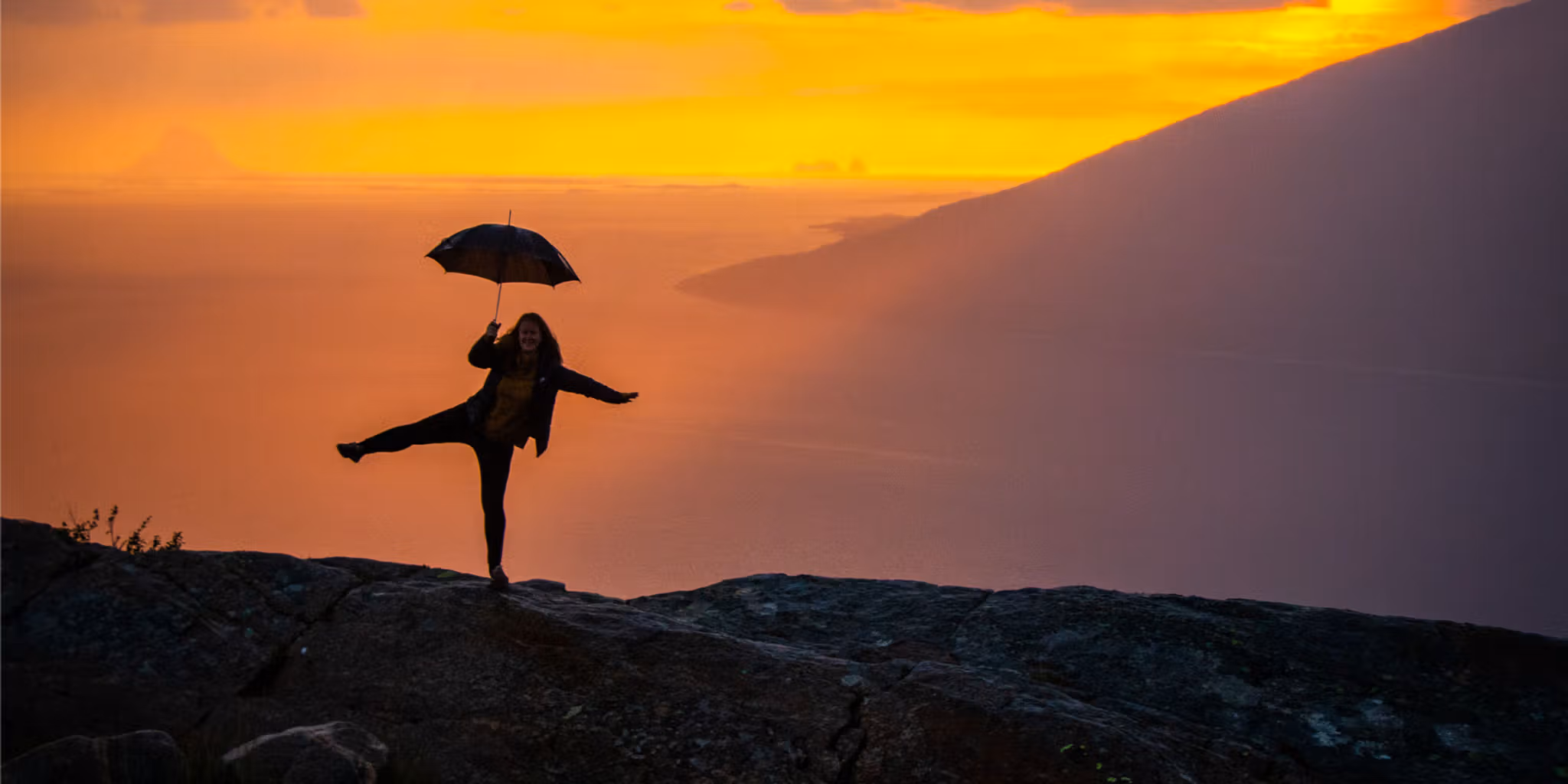 Girl holding an umbrella at the Sjonfjellet mountain in Northern Norway