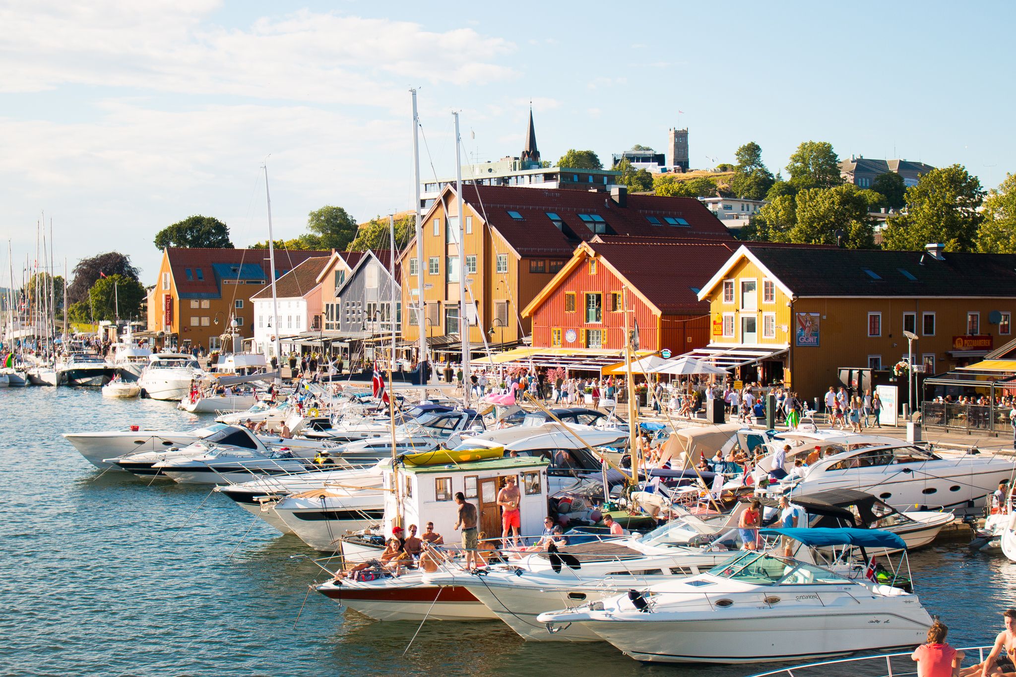 Båtar och människor en solig dag i hamnen i Tønsberg, Vestfold i regionen Østlandet (östra Norge)