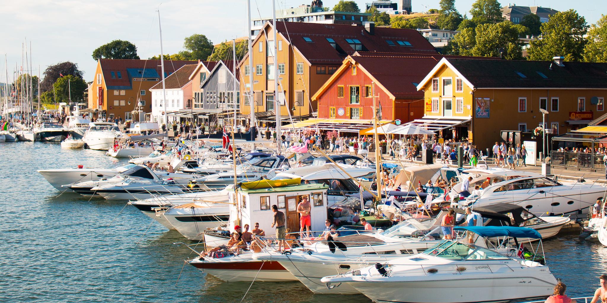 Båtar och människor en solig dag i hamnen i Tønsberg, Vestfold i regionen Østlandet (östra Norge)