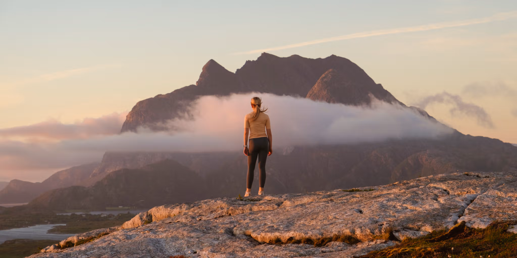 A woman going on a midnight hike to Øksningan, Helgeland, Norway.