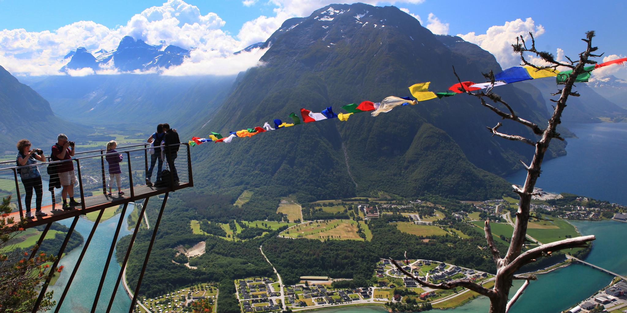 People standing on the Rampestreken viewpoint overlooking the city of Åndalsnes in Northwest, Fjord Norway