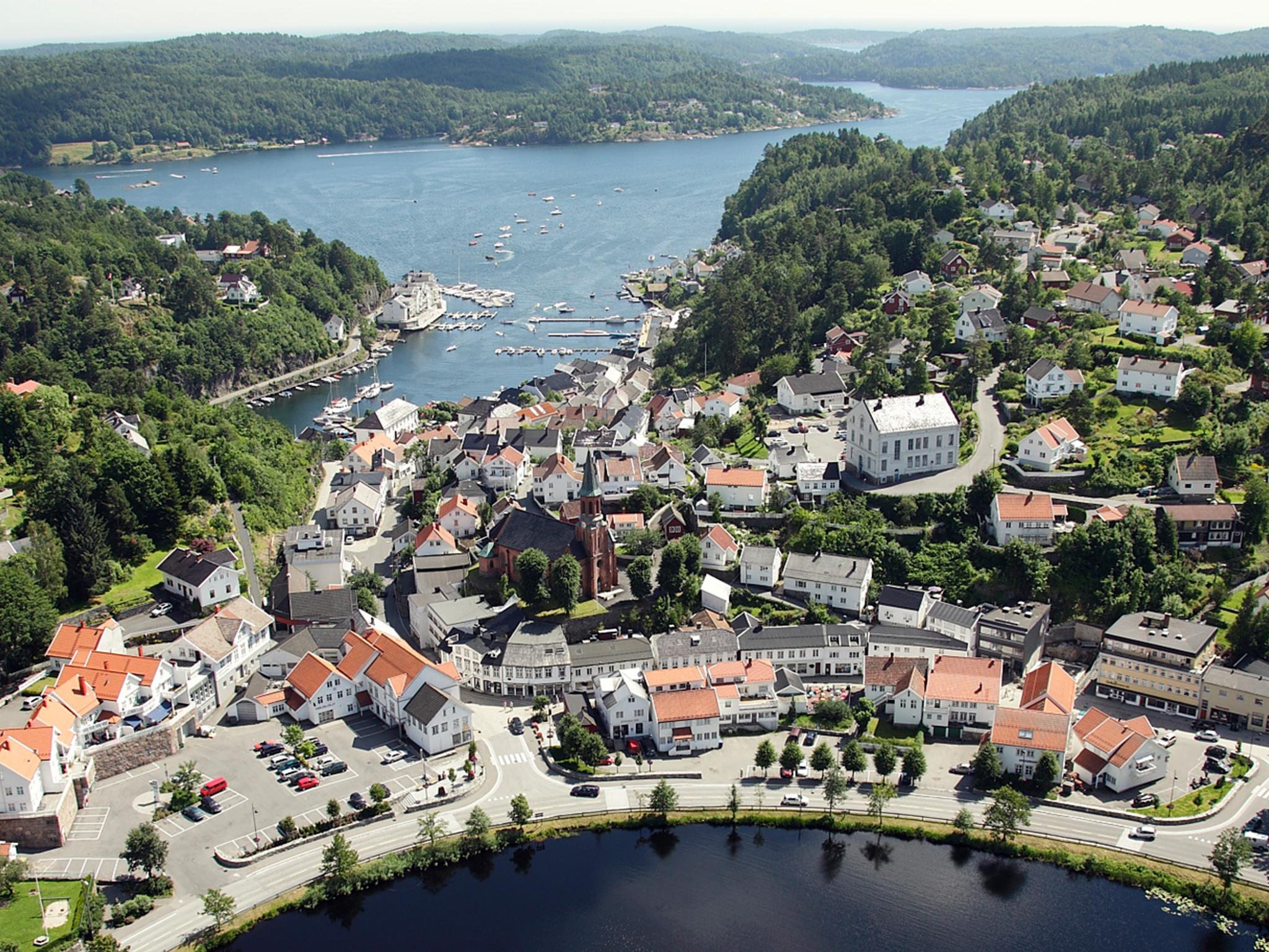 The idyllic white-painted city of Tvedestrand from the air, between the fjord and the city lake Tjenna. Southern Norway.