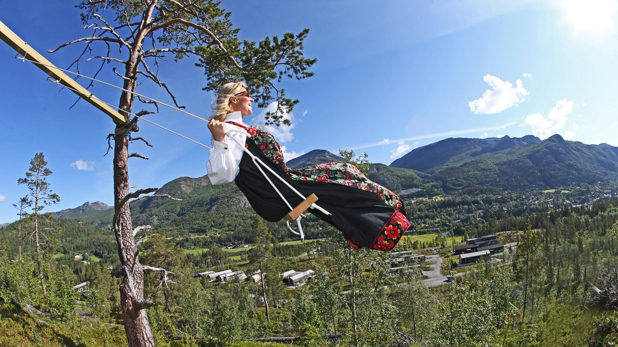 Una mujer, sentada en un columpio ataviada con el traje típico de Hemsedal, el "bunad", en el Este de Noruega.