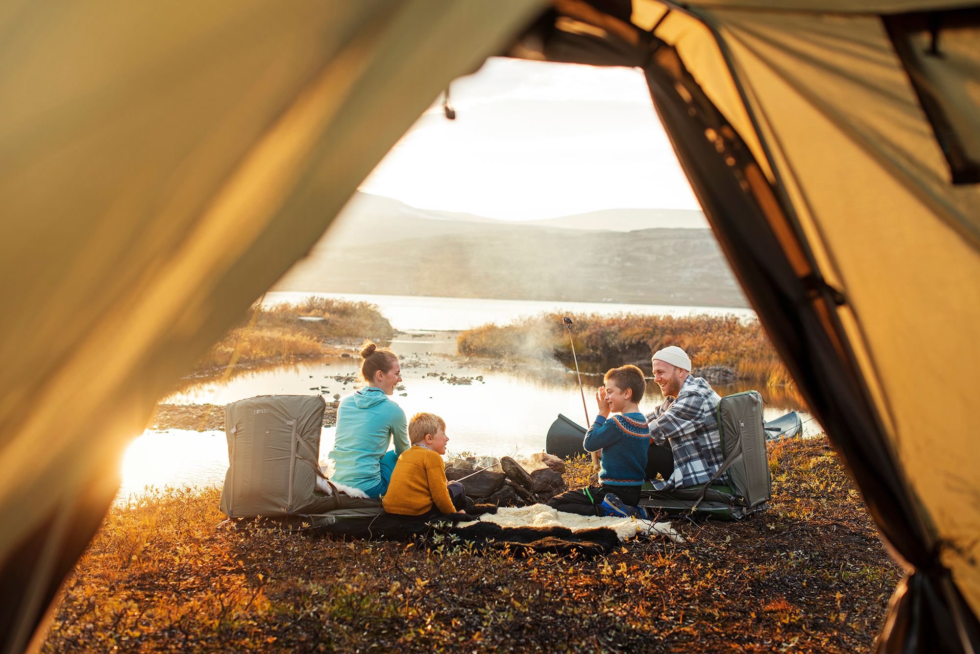 A family outside a tent in sunset in Oppdal in Trøndelag, Norway