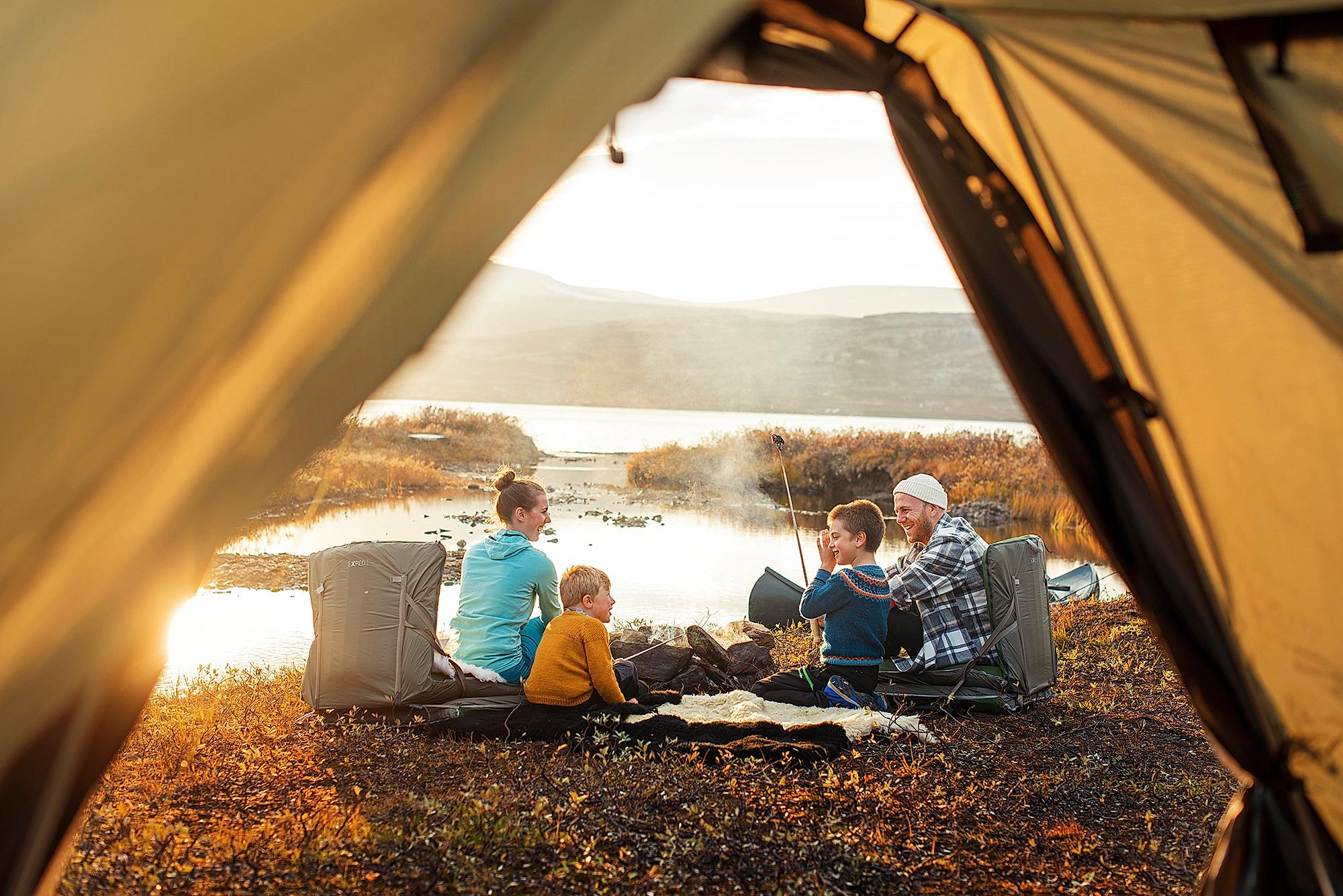 A family outside a tent in sunset in Oppdal in Trøndelag, Norway