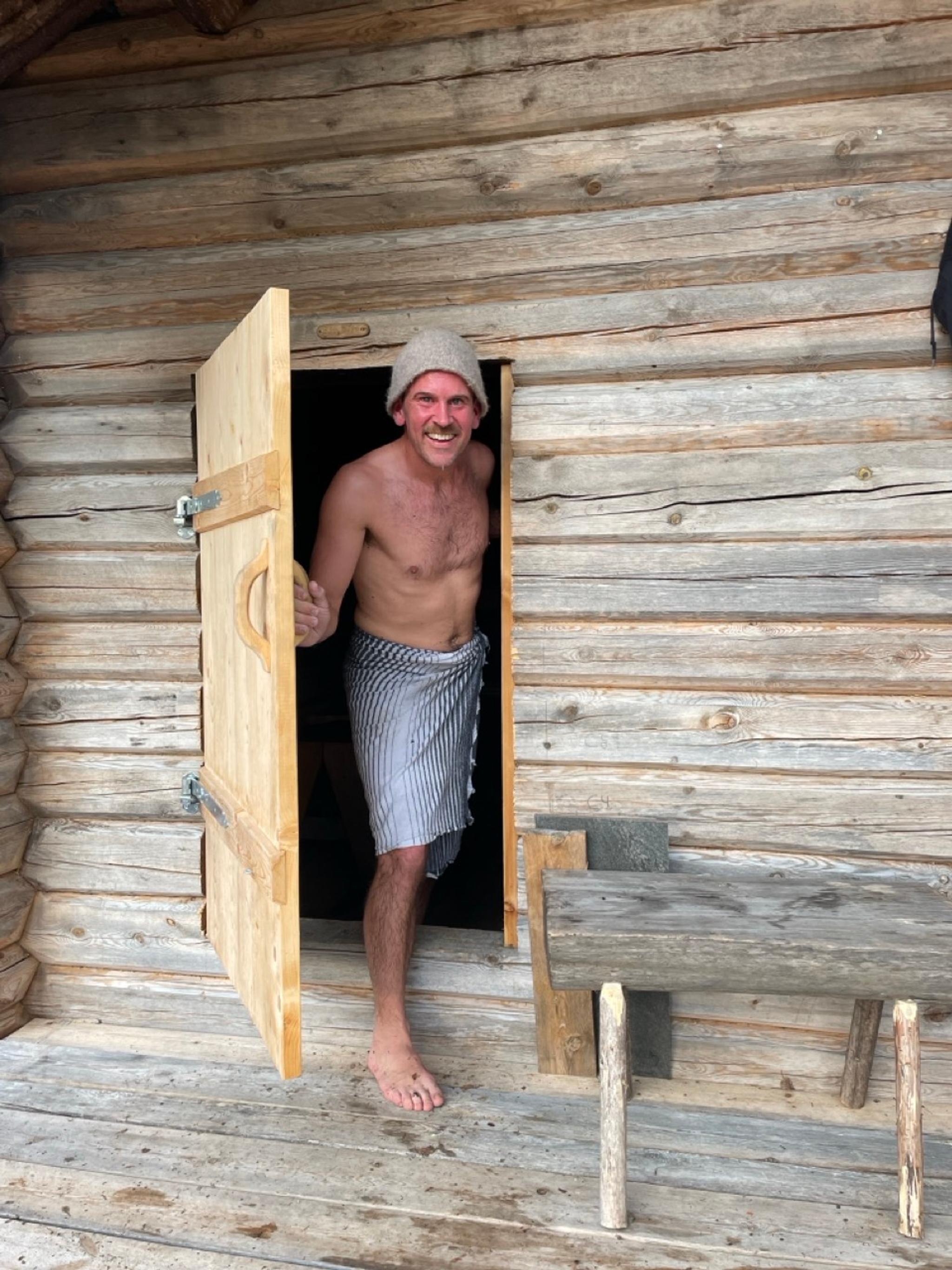 A man on his way out of a sauna.