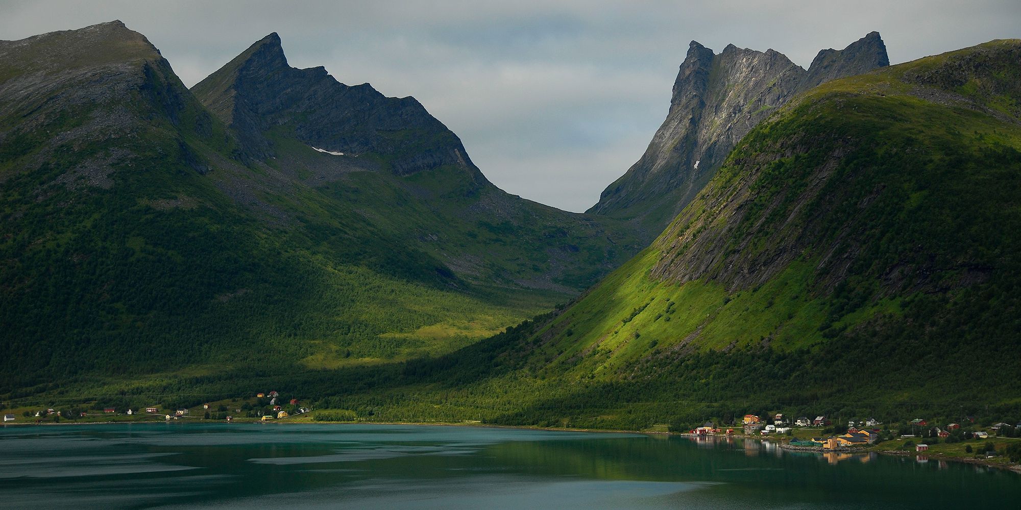 Bratte fjell i Senja som stiger opp fra sjøen