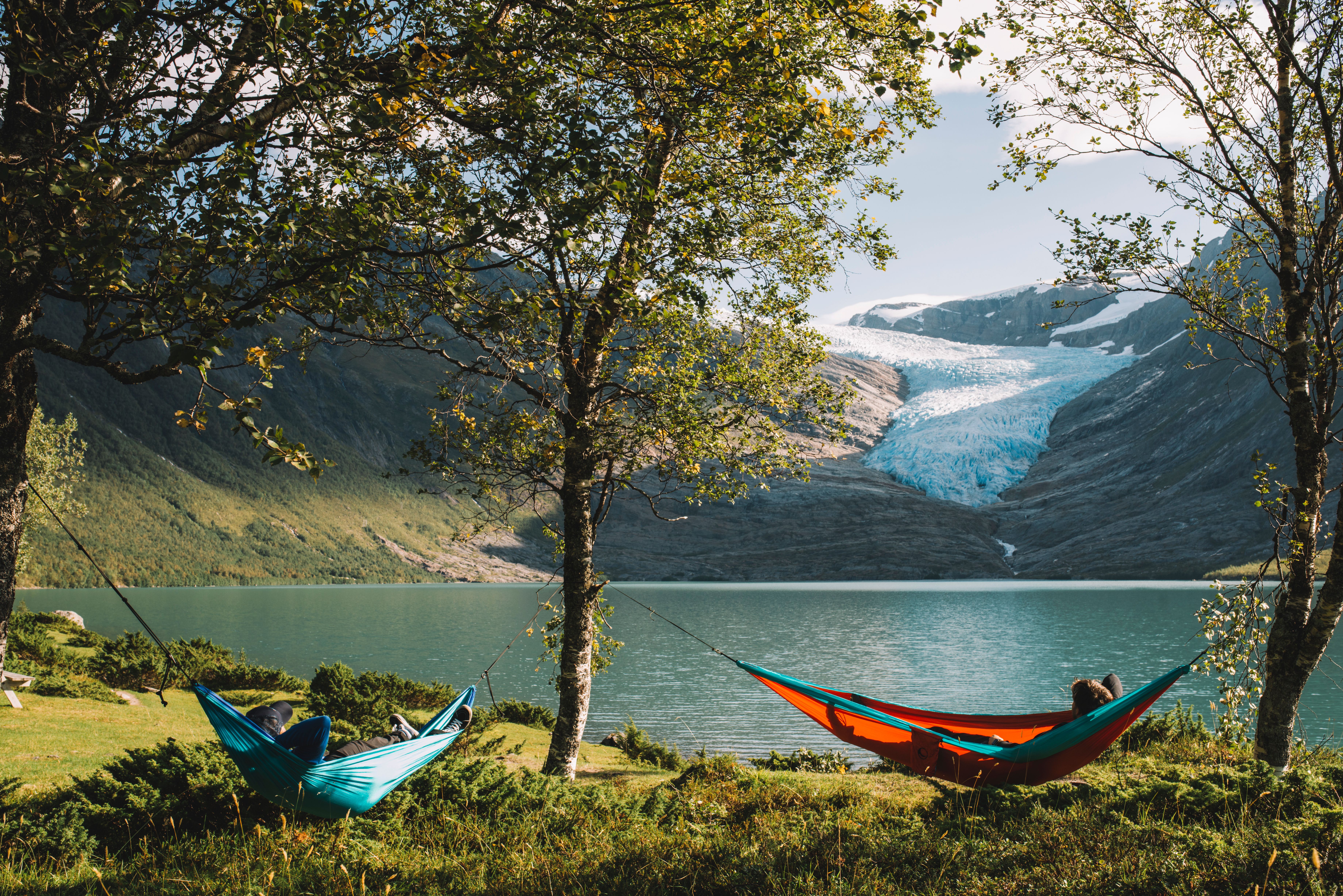 People in hammocks in front of the Svartisen glacier in Helgeland, Northern Norway