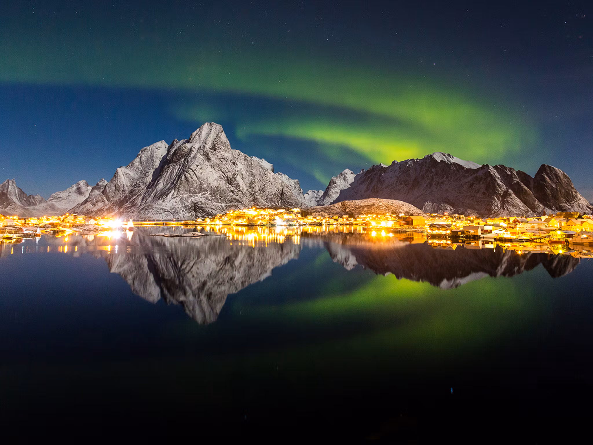 The northern lights over the fishing village Reine in Lofoten, Northern Norway
