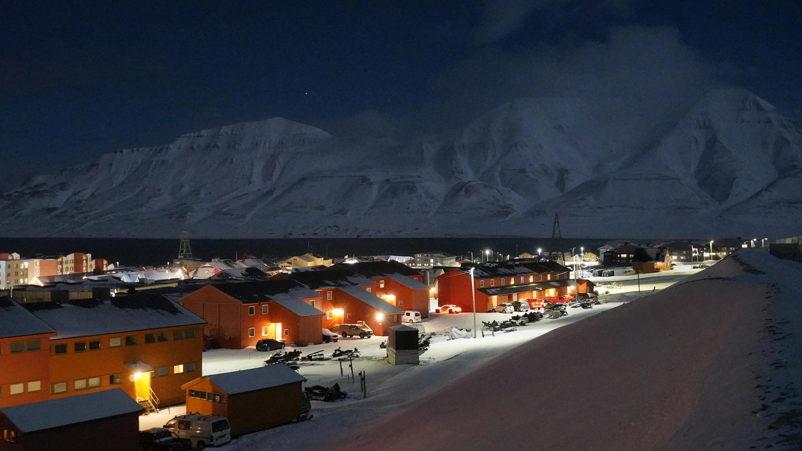 Røde hus og hvite fjell i polarnatten