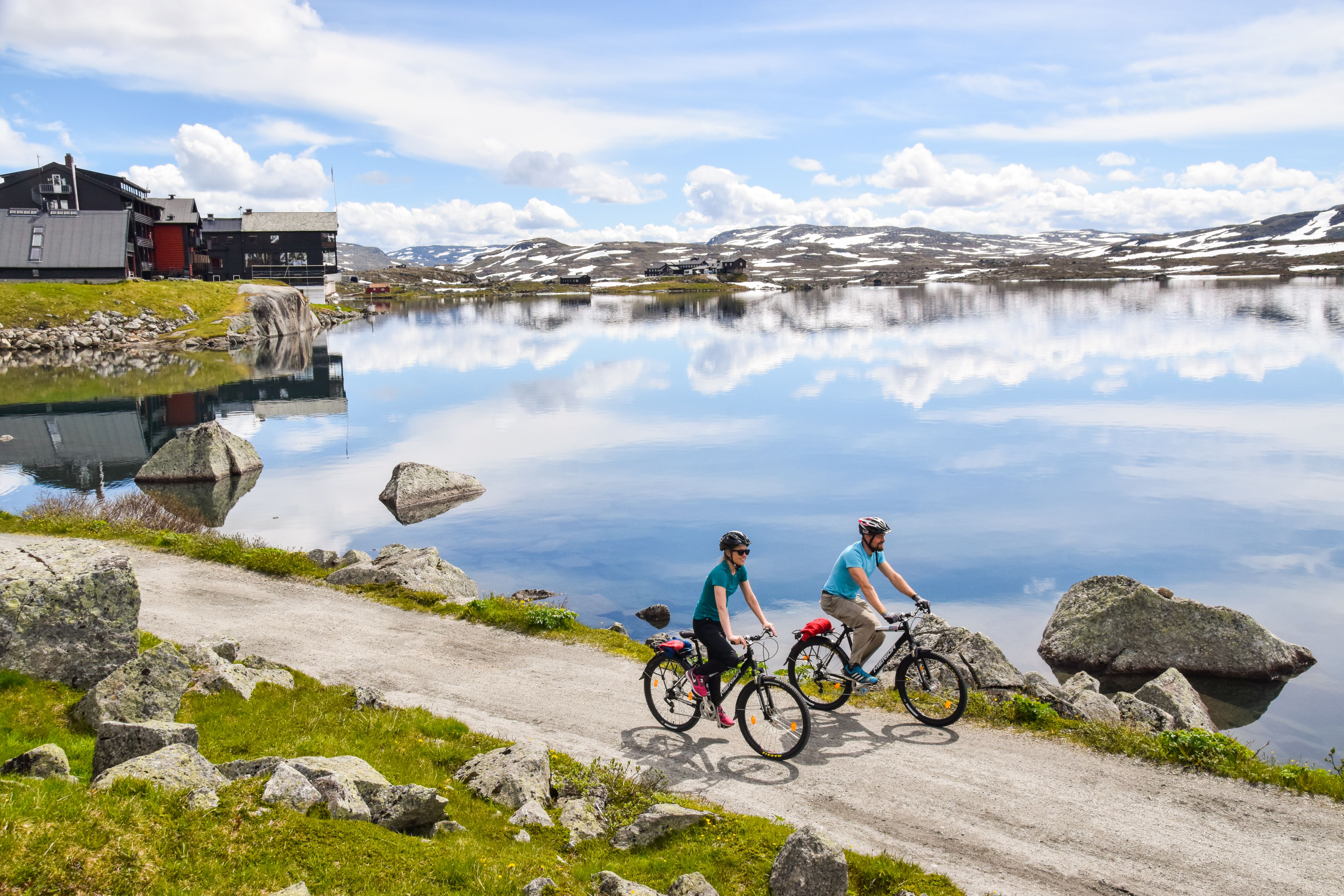 Two people on bikes next to a lake