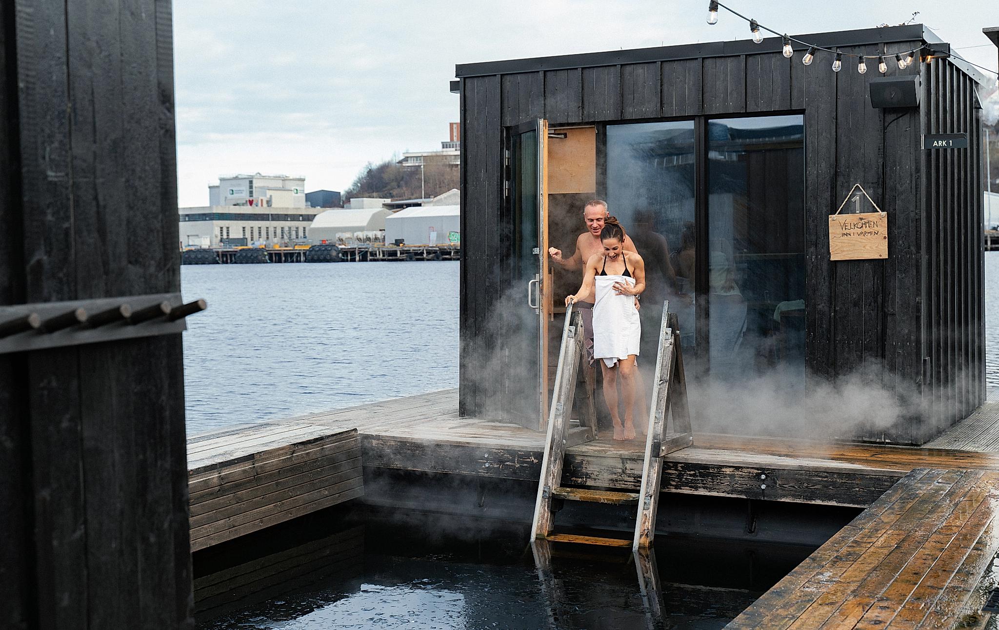 A man and a woman heading out from a steaming hot sauna into a chilling batch in Trondheim
