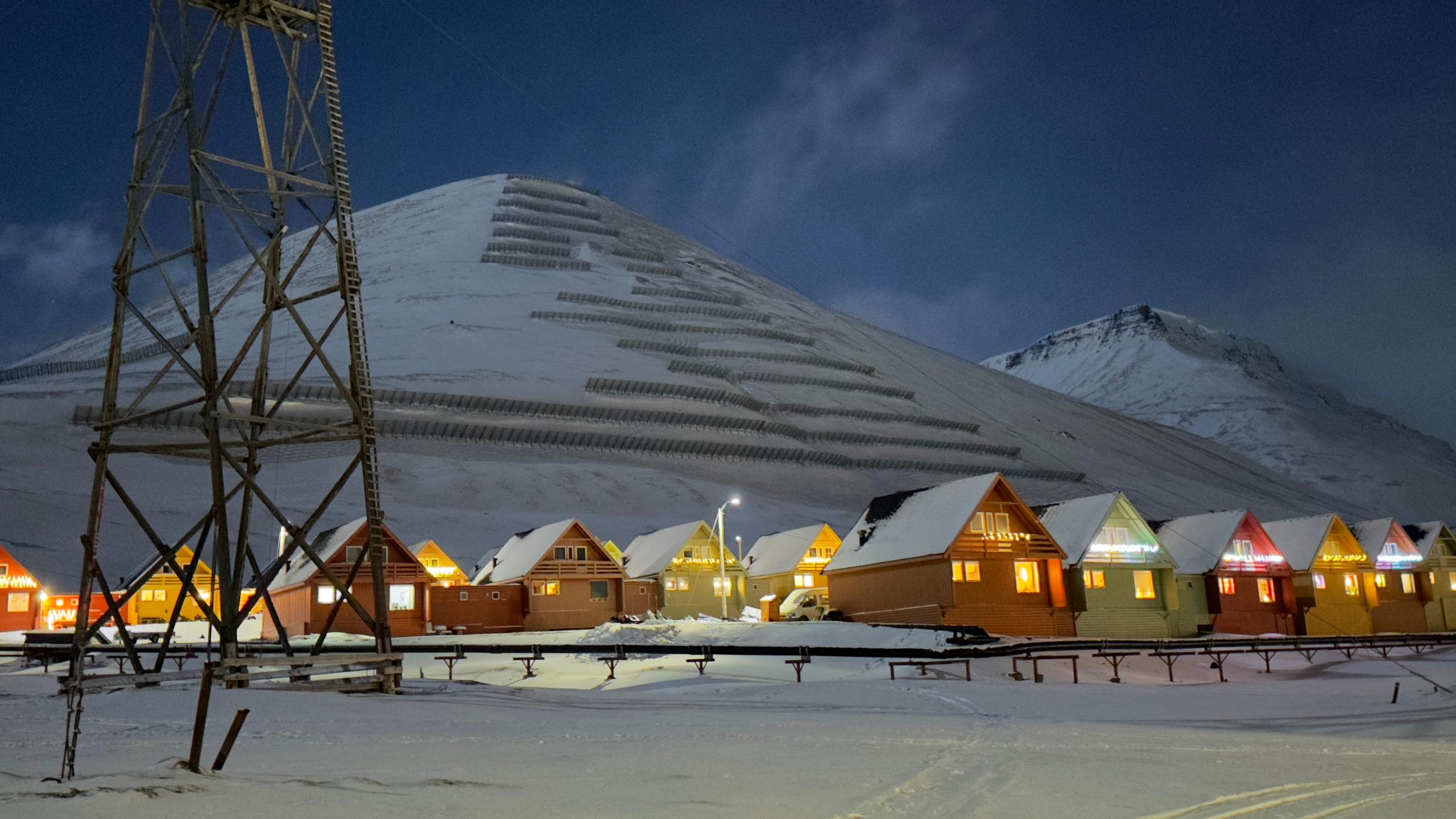 Tiny houses in front of a big mountain in winter