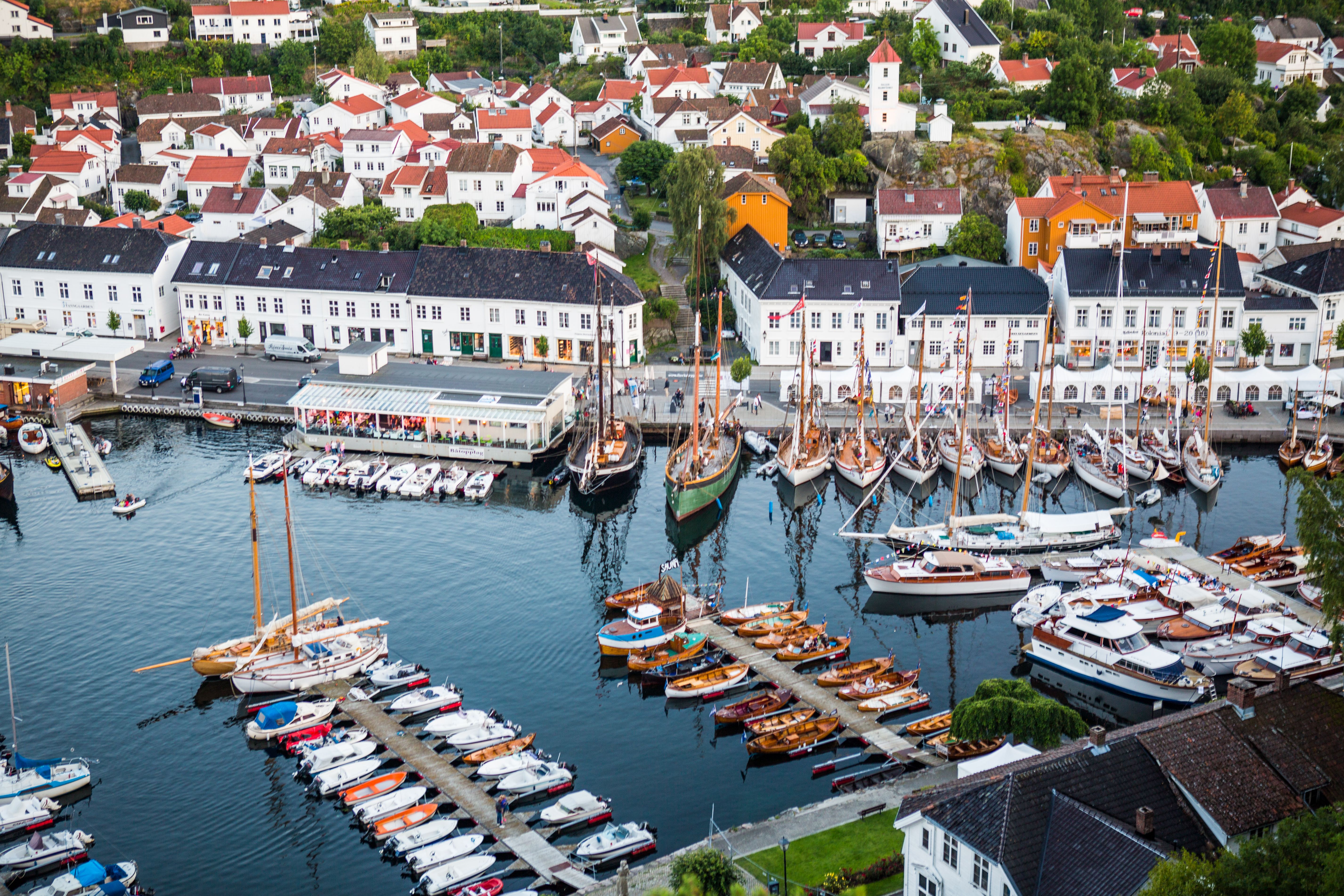 Båter i Risør havn, hvitmalte hus i bakgrunnen