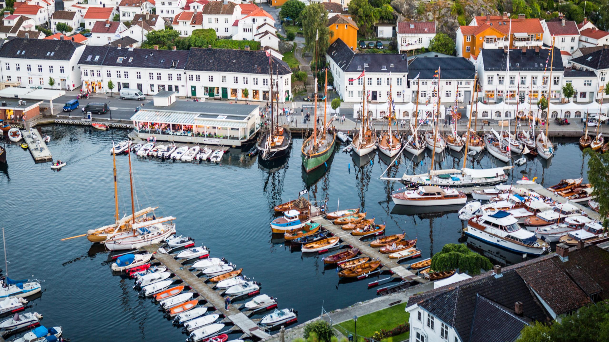 Boats in Risør harbour with white-painted houses in the background