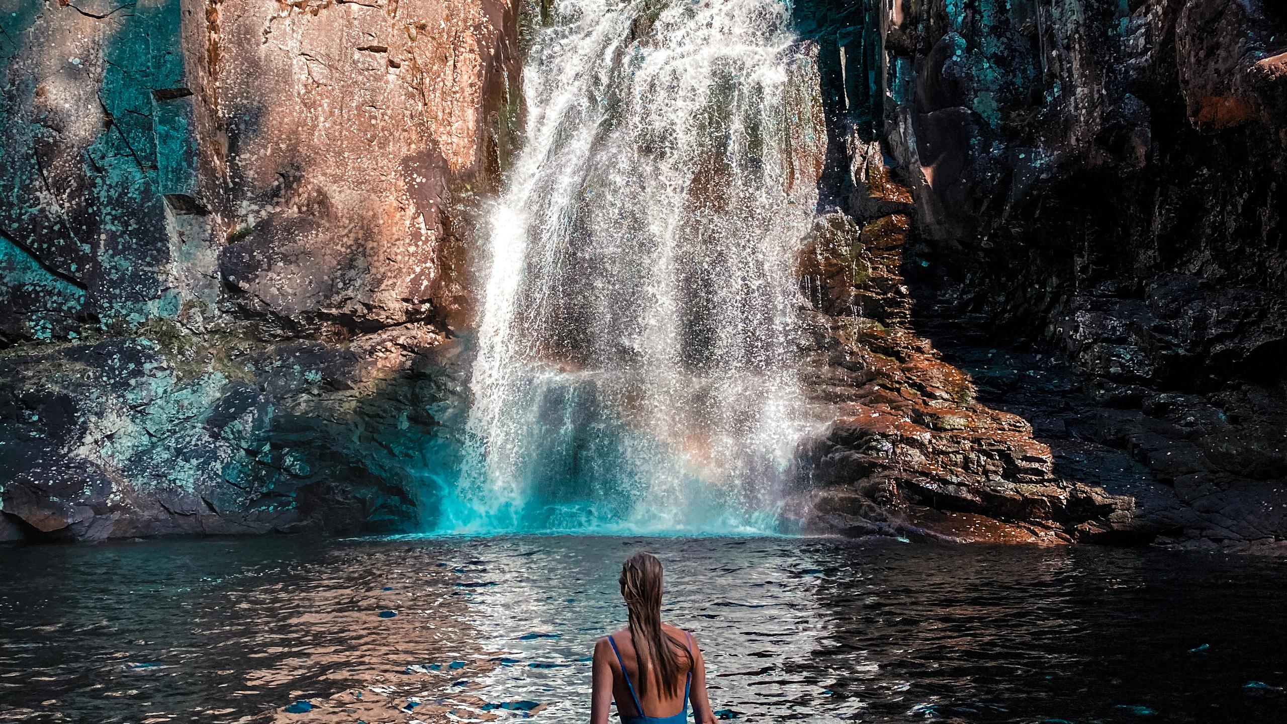 En kvinne bader foran Trollfoss