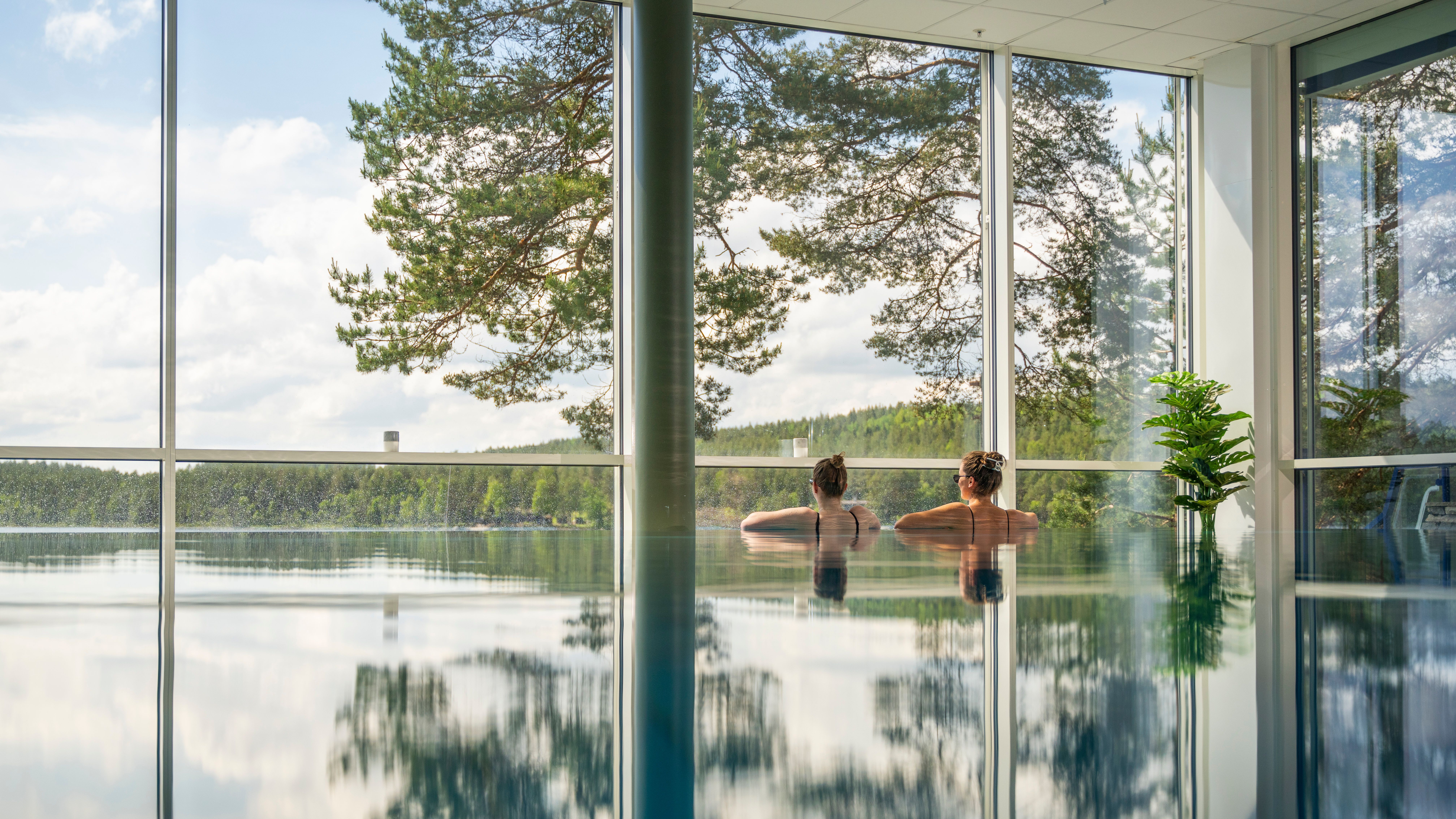 Damer som nyter utsikten fra bassenget på Rømskog Spa & Resort