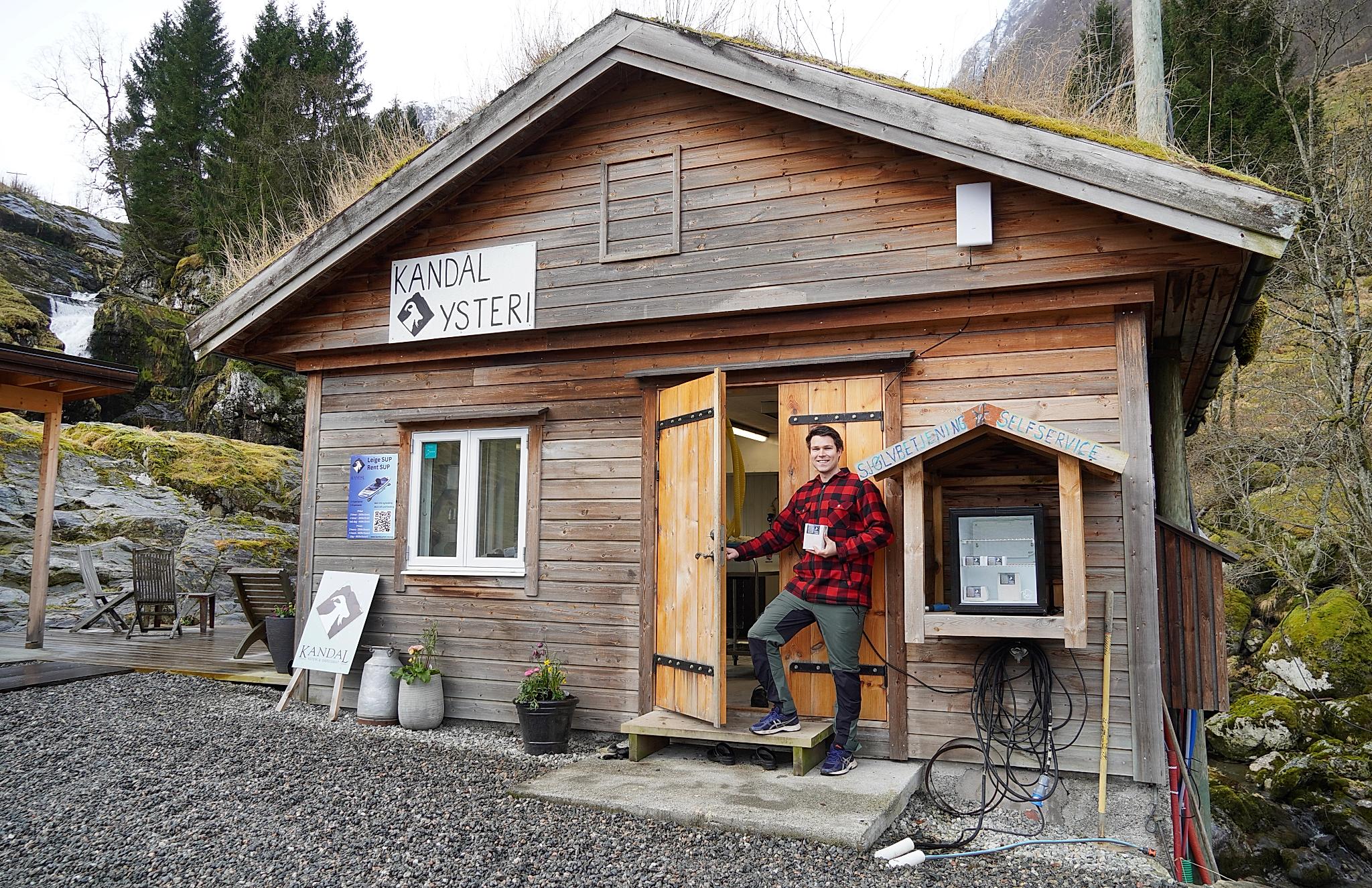 A man standing outside a self service brown cheese shop in Kandal in gloppen in Western Norway.