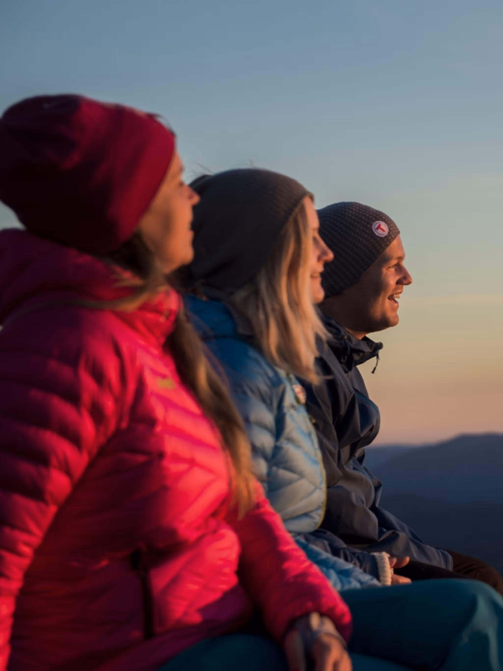 Three people enjoying the view from Mount Gaustatoppen in Telemark, Eastern Norway