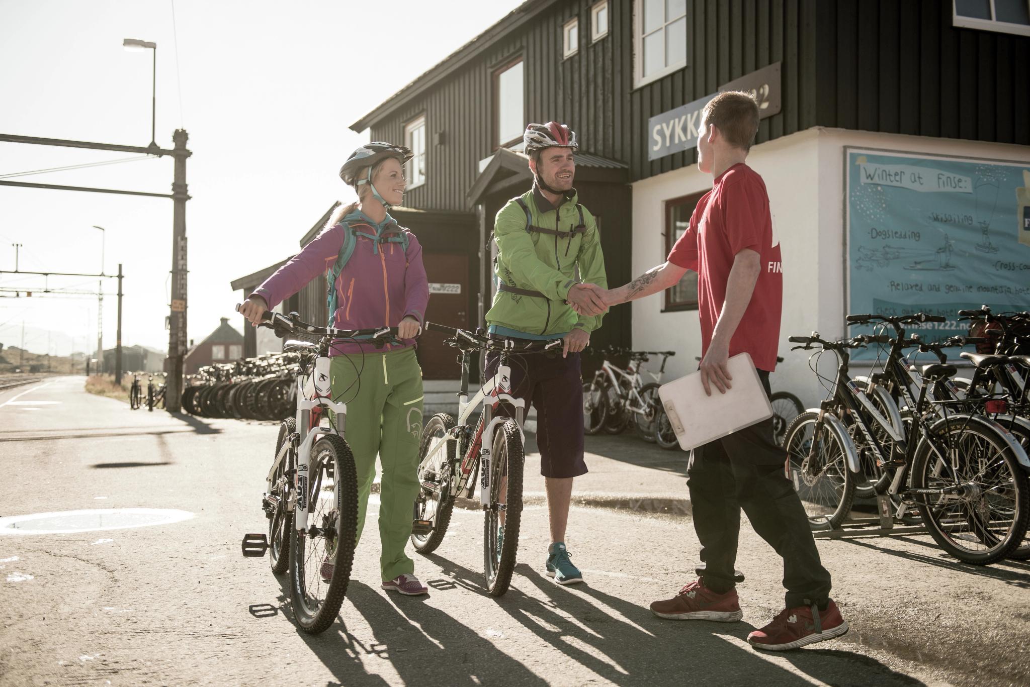 Två cyklister hyr cyklar i Finse inför turen längs Rallarvegen i regionen Fjord Norge (Vestlandet)