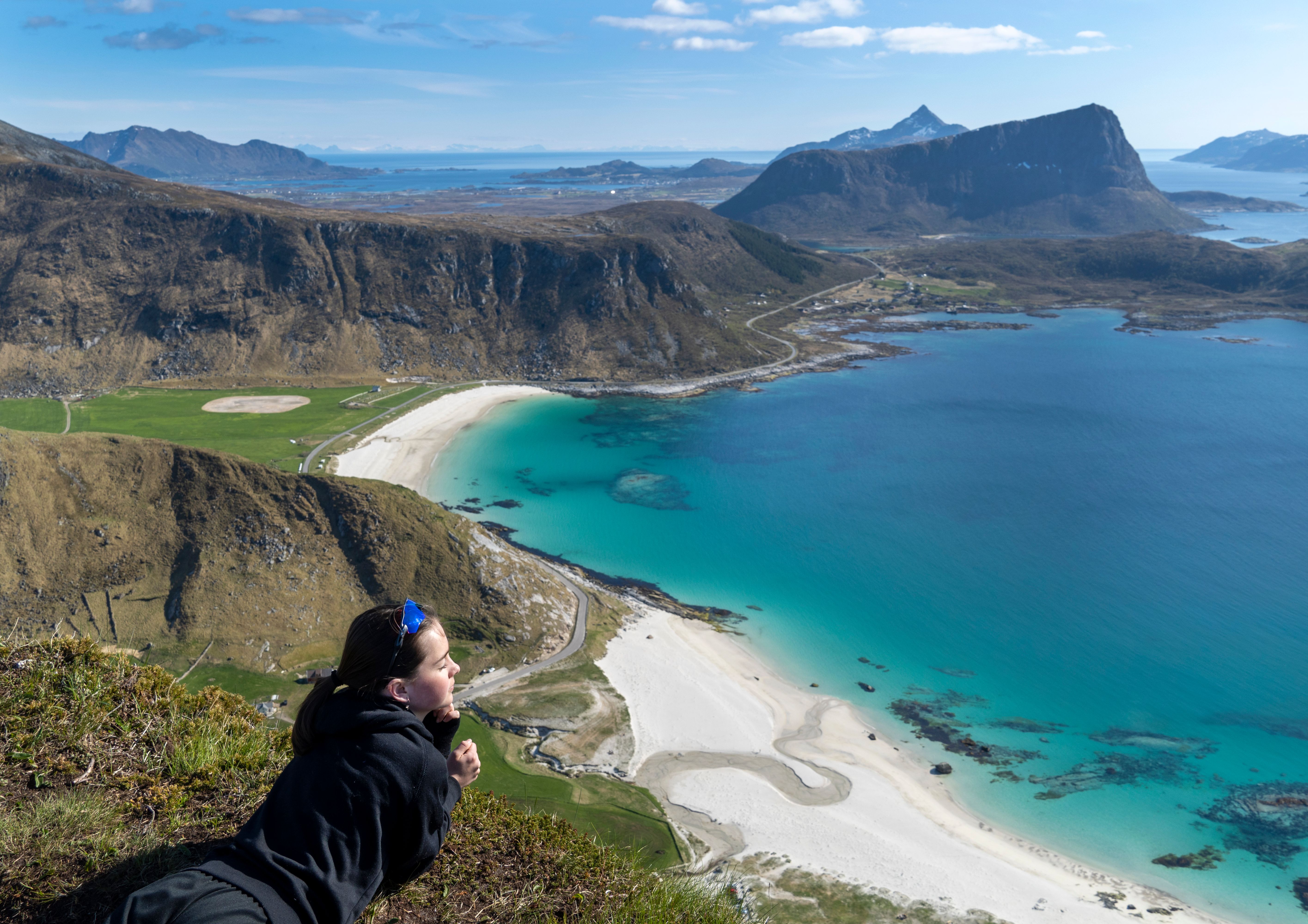 Flicka som njuter av utsikten från fjället vid Hauklandstranda i Lofoten i Nord-Norge