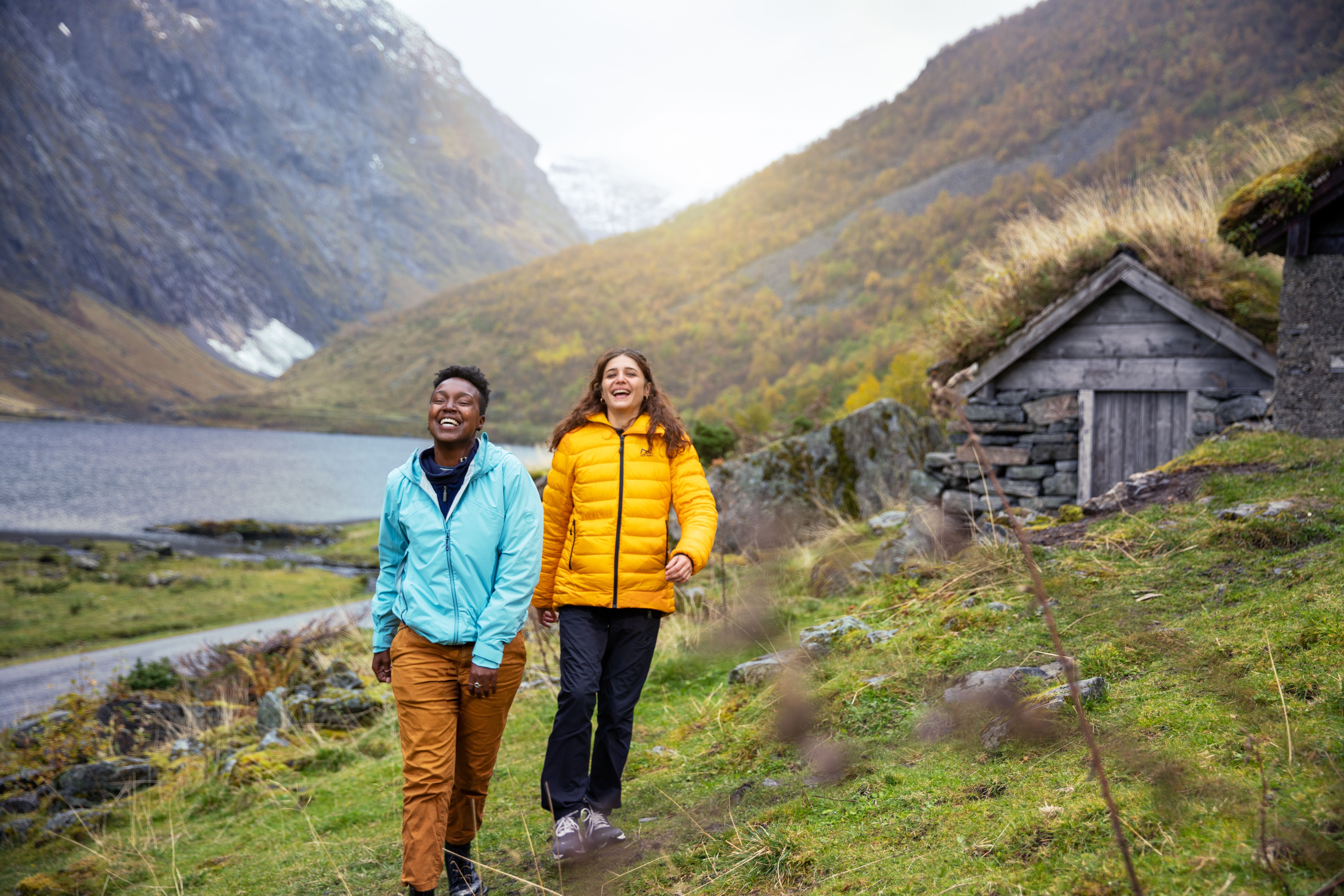 Two women hiking by the Hjørundfjord in Fjord Norway in autumn