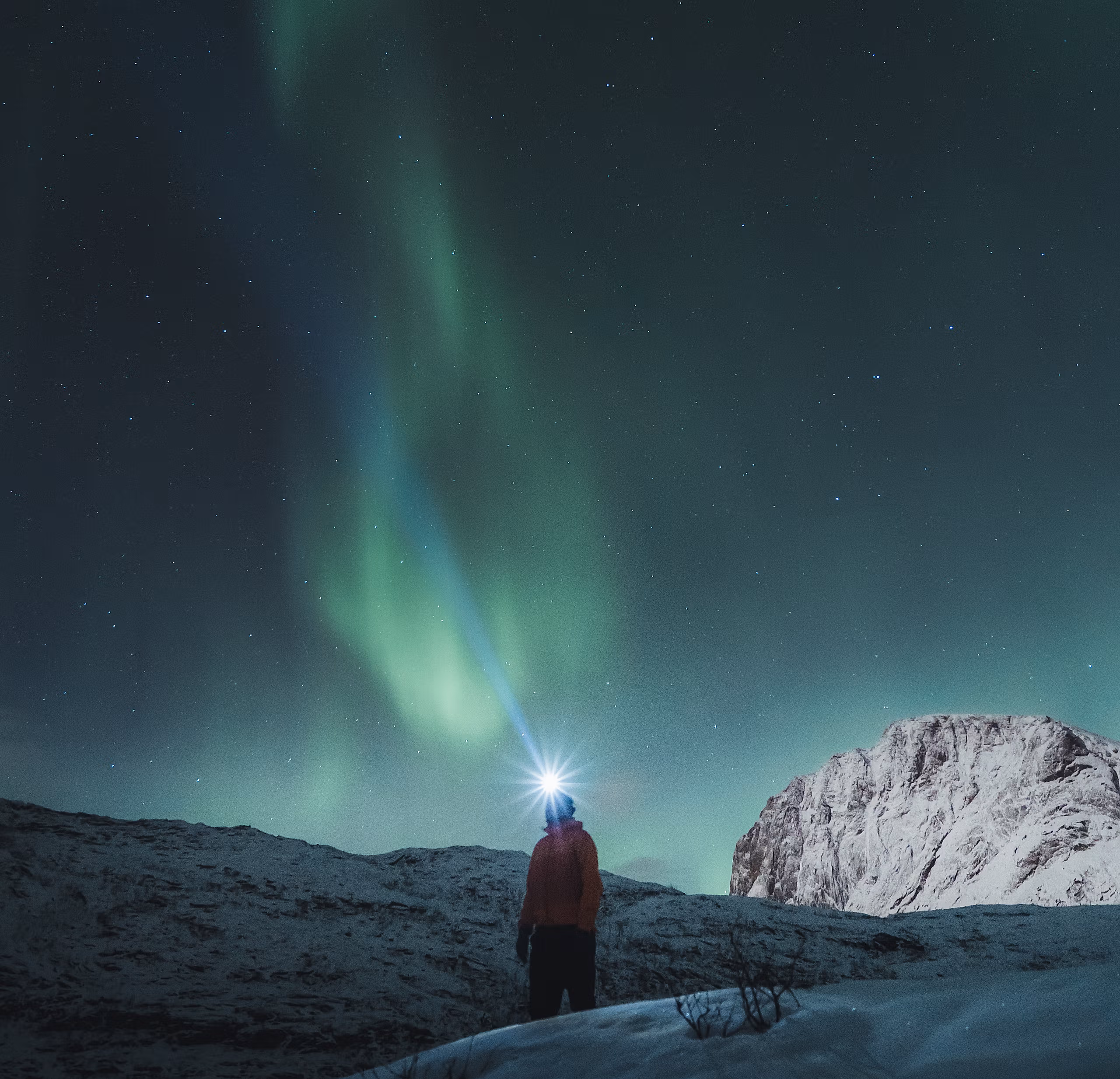 Man watching the northern lights over Mefjordsletta, Senja