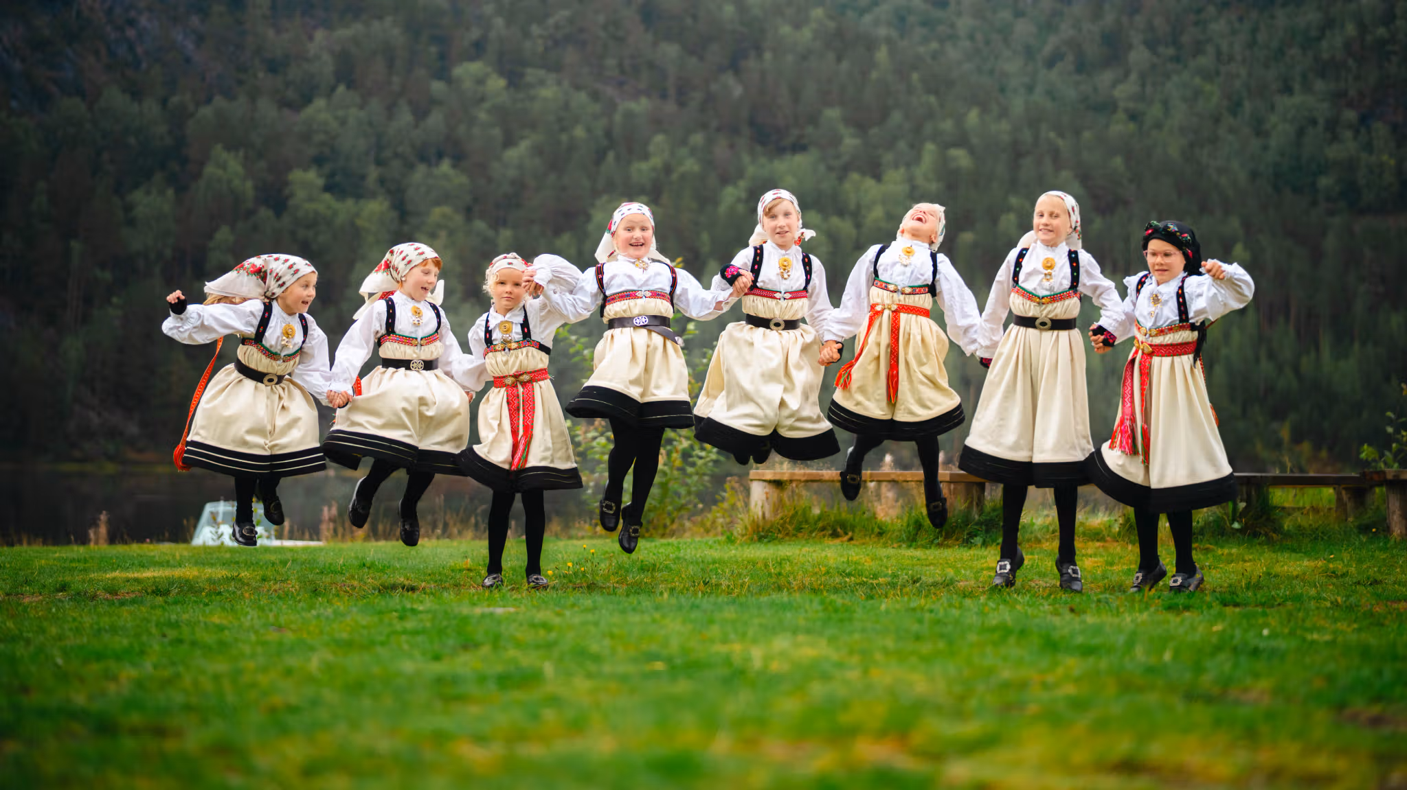 Young girls in Setesdalsbunad jumping of joy