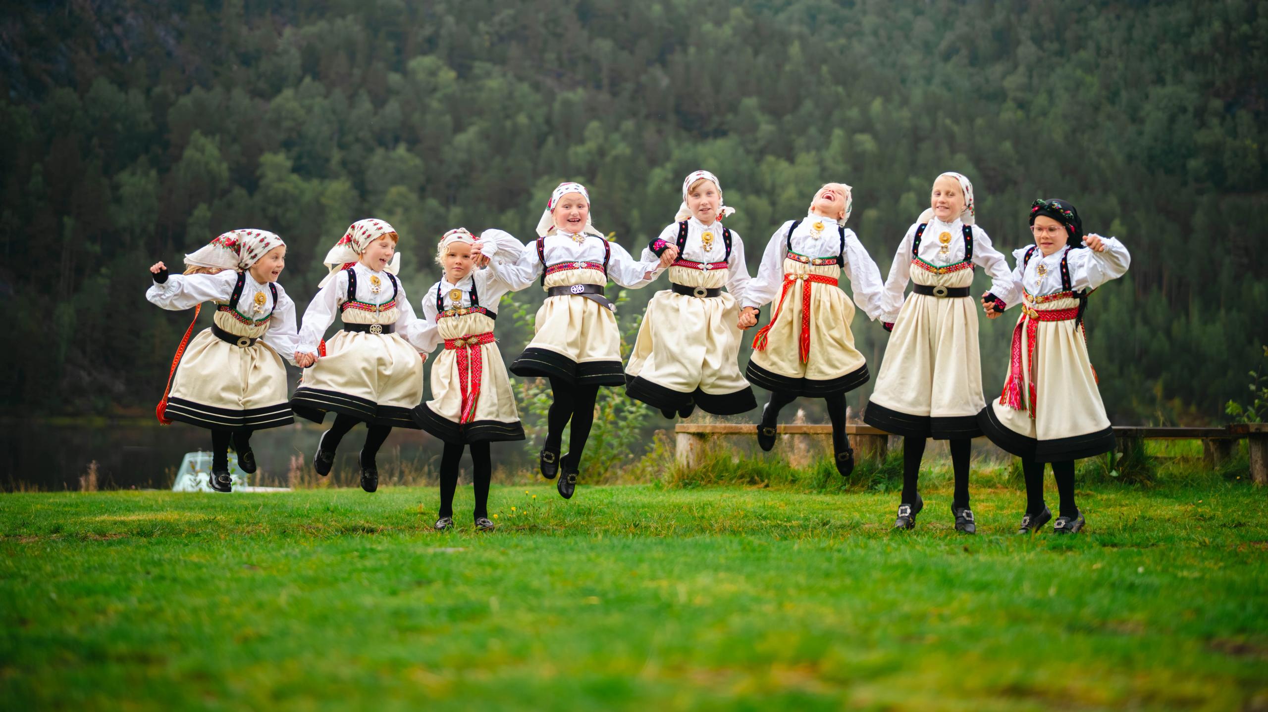 Young girls in Setesdalsbunad jumping of joy