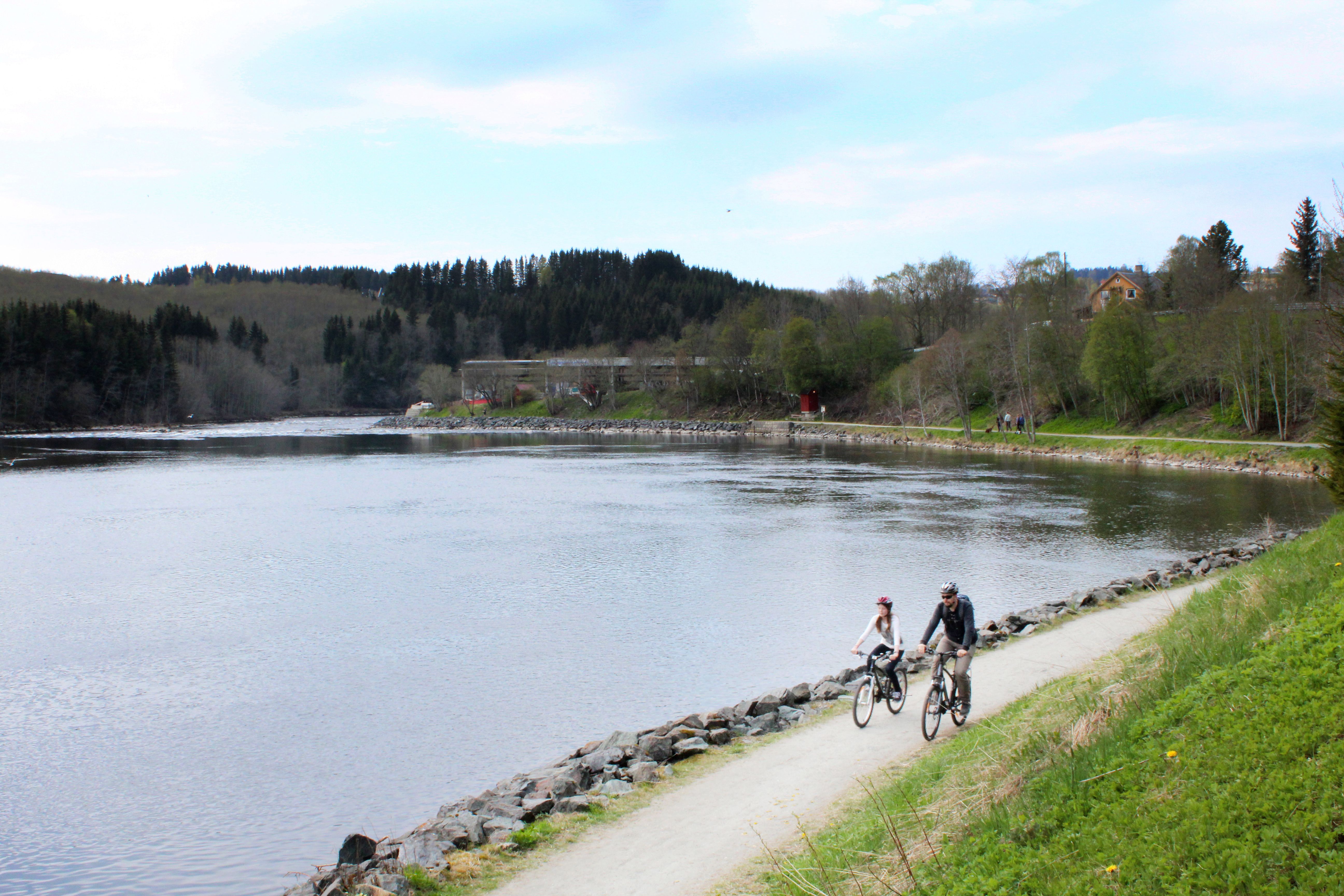 Father and daughter cycling along the Nidelva river in Trondheim, Trøndelag