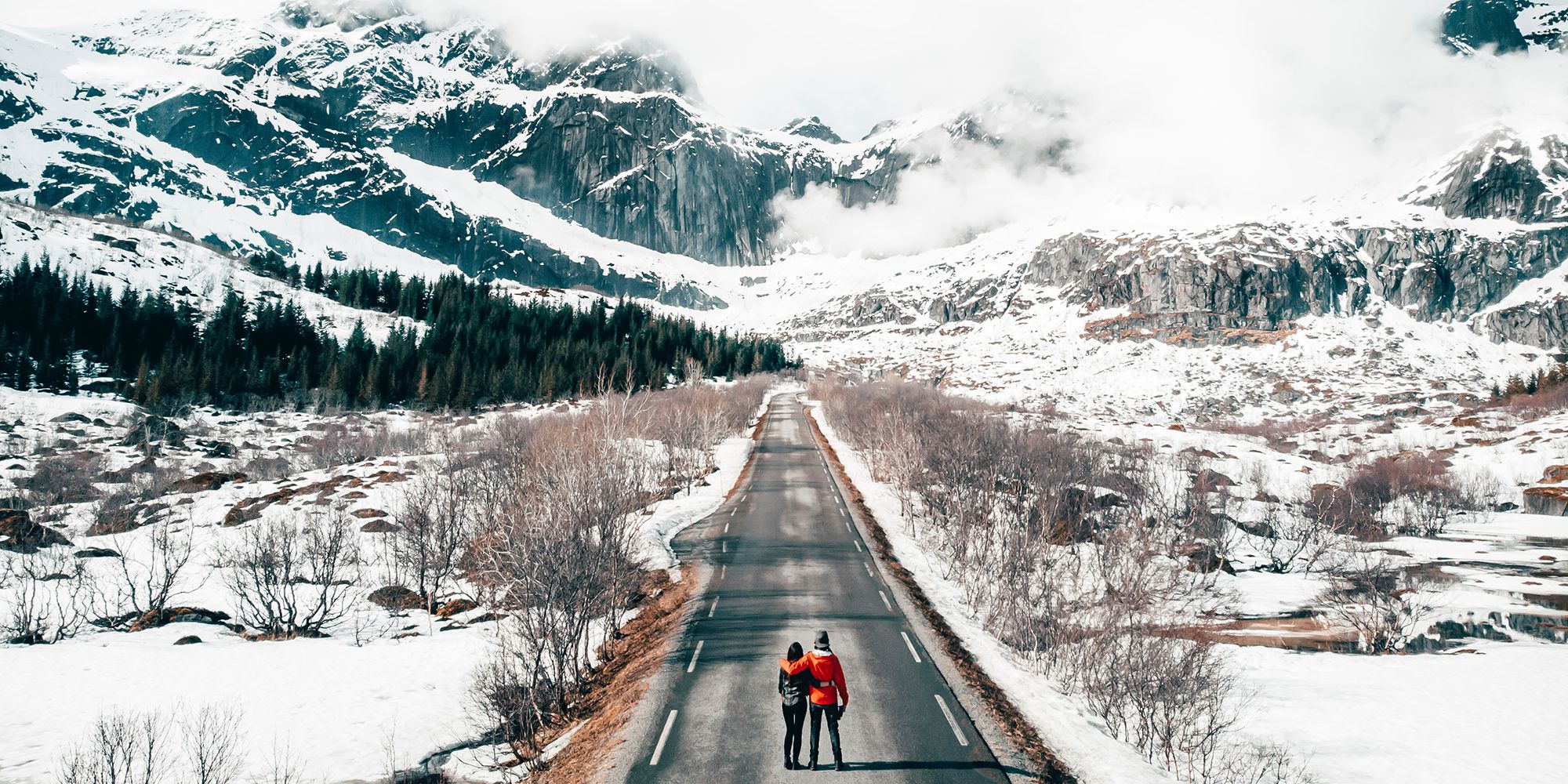 Coppia su una strada nelle Lofoten imbiancate di neve, Norvegia settentrionale