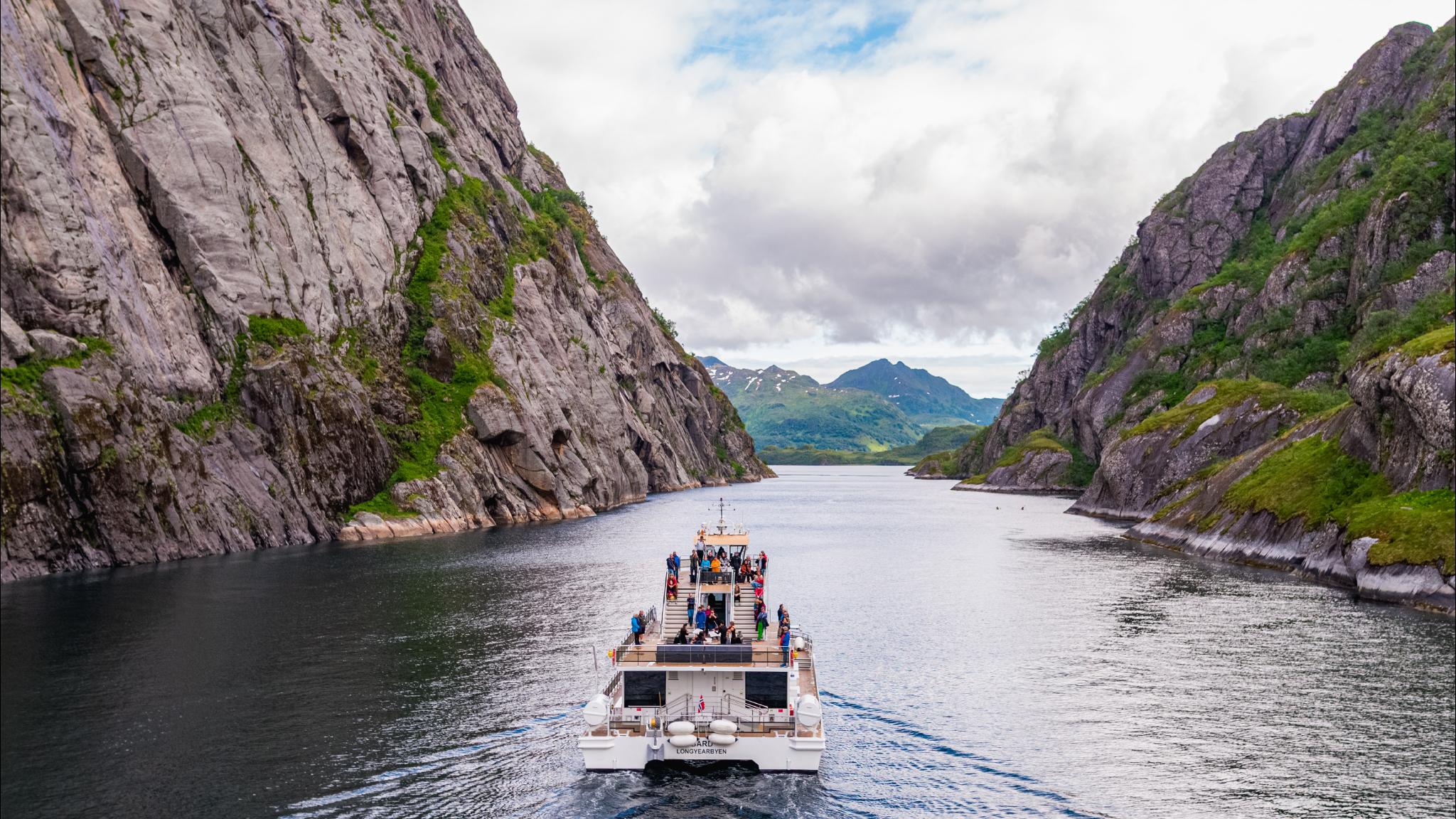 A big boat sailing past mountains.