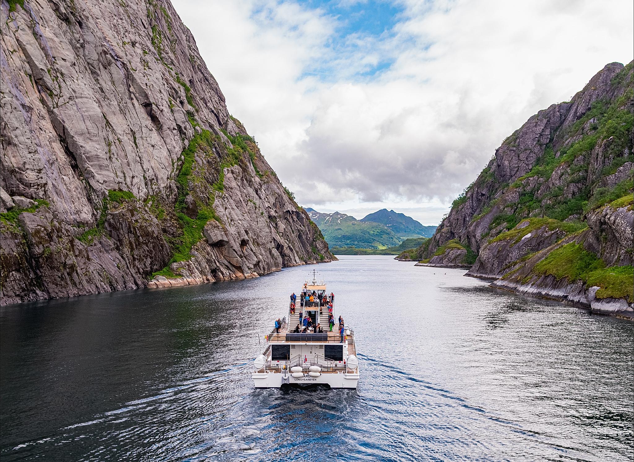 A big boat sailing past mountains.