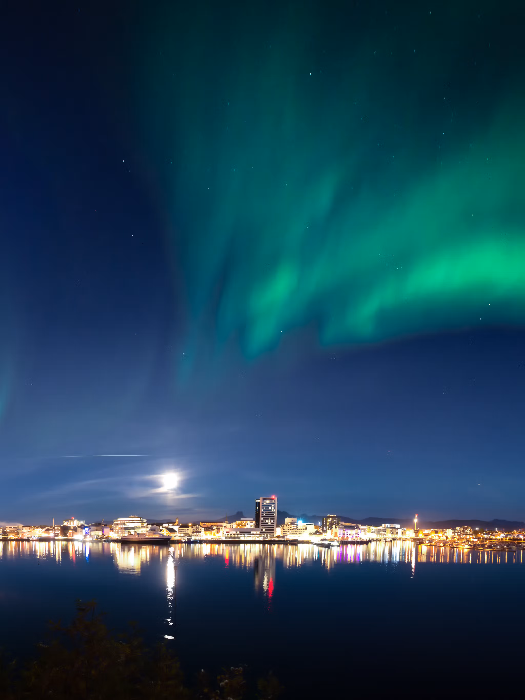 The northern lights dancing across the sky above the city of Bodø, Northern Norway