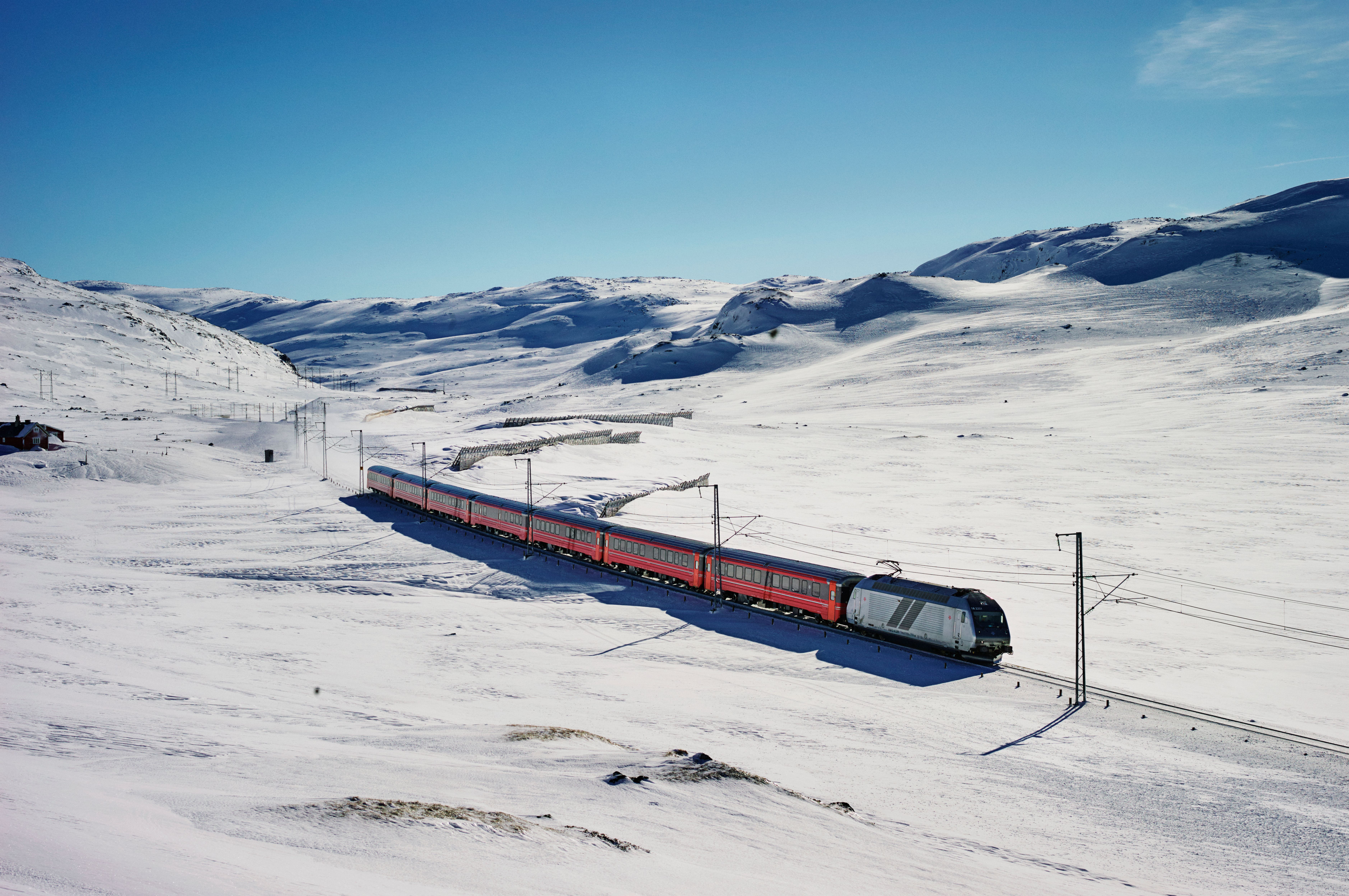 Et tog kjører på Bergensbanen gjennom et vinterkledd fjellandskap