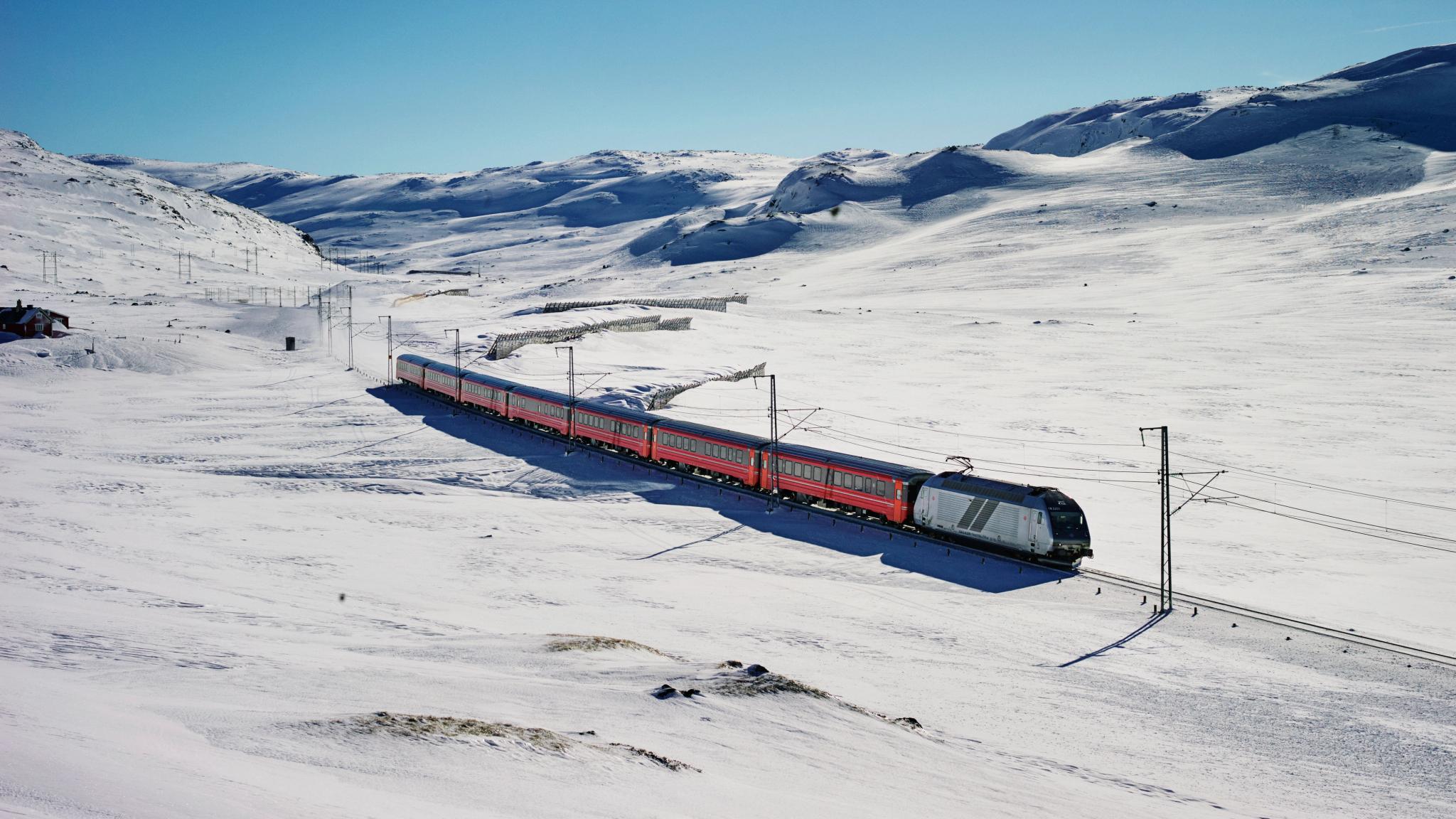Et tog kjører på Bergensbanen gjennom et vinterkledd fjellandskap
