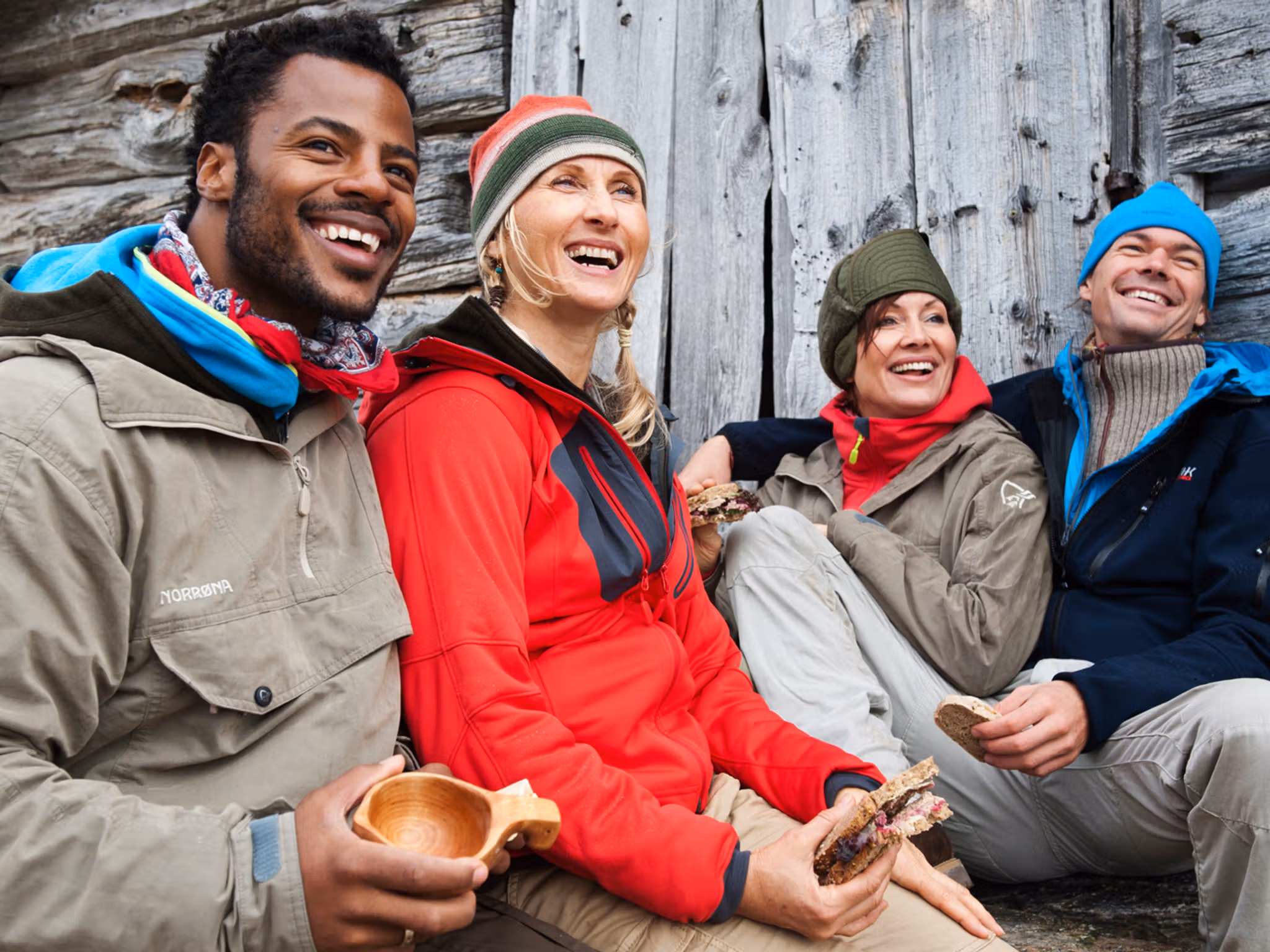 Four people resting outside of a mountain cabin in Beitostølen, Norway