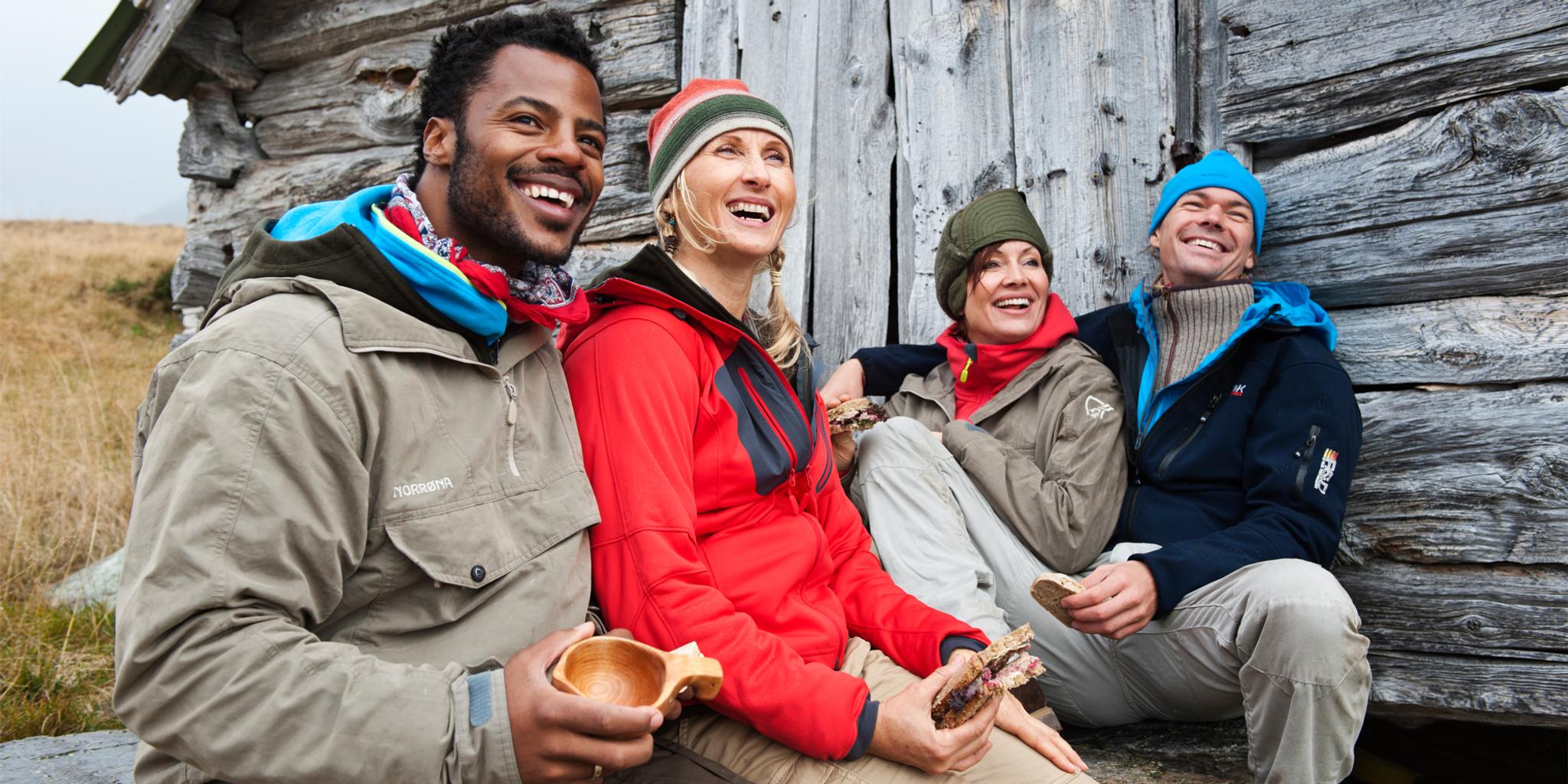 Four people resting outside of a mountain cabin in Beitostølen, Norway