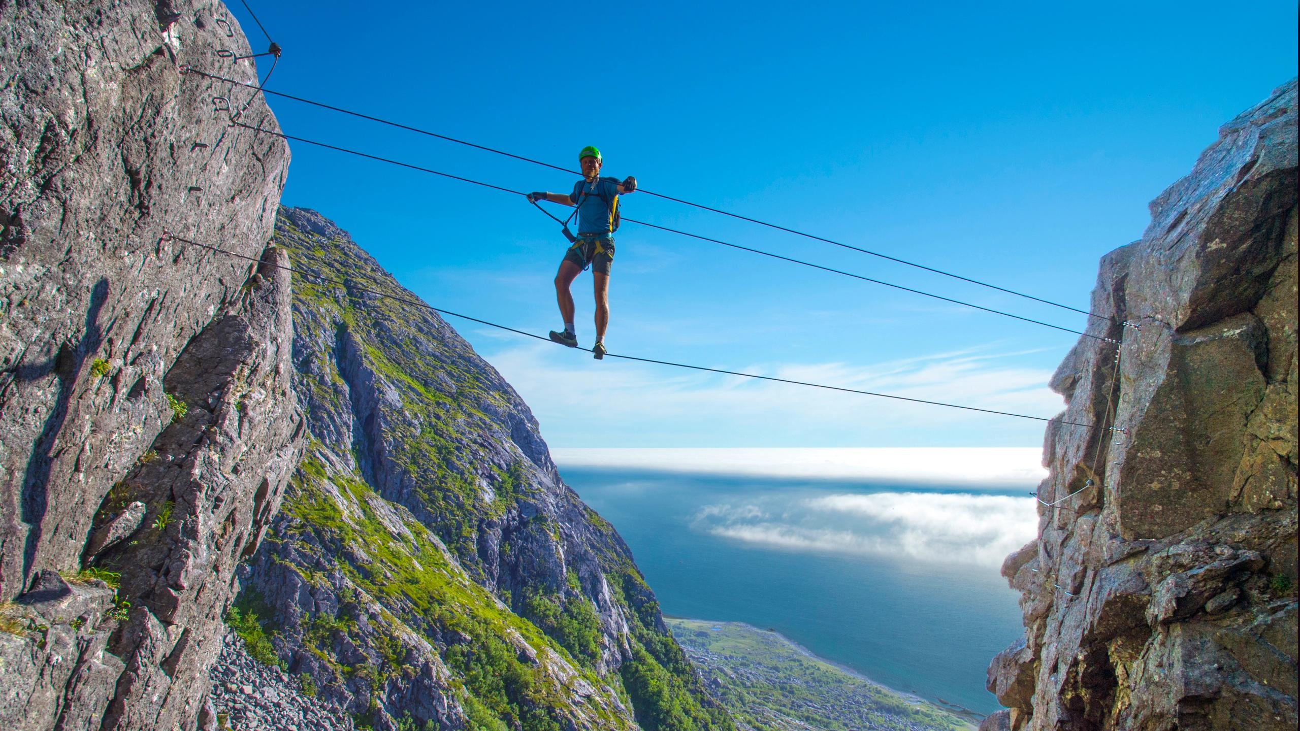 En mann klatrer Ravnfloget Via ferrata i Vega