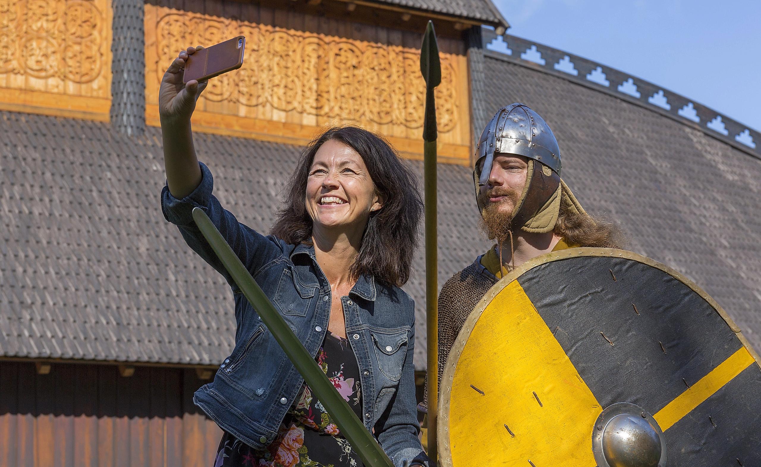 A woman takes a selfie with a Viking at Midgard viking centre in Borre in Vestfold, Eastern Norway
