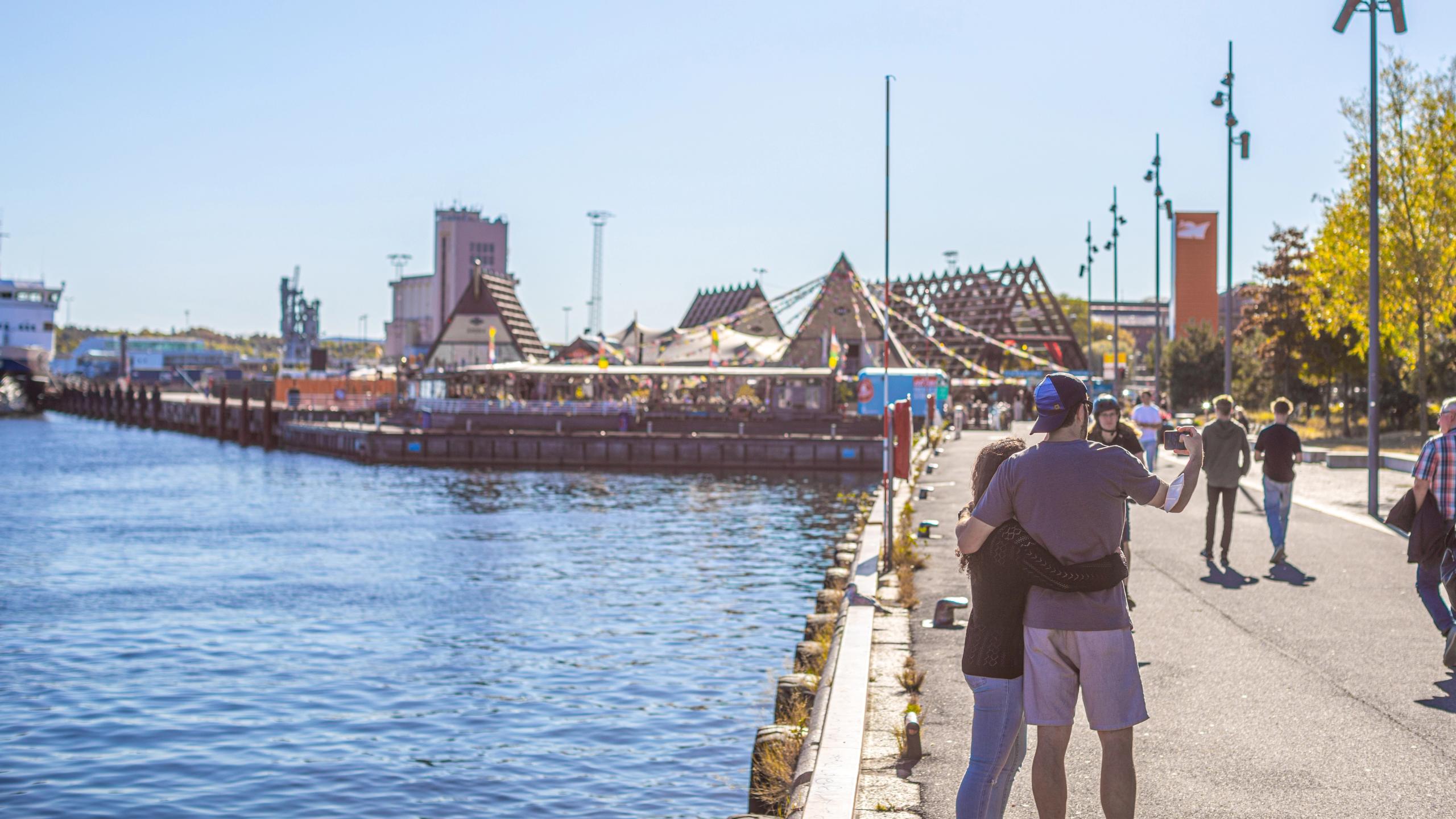 Couple taking pictures in front of SALT in Oslo