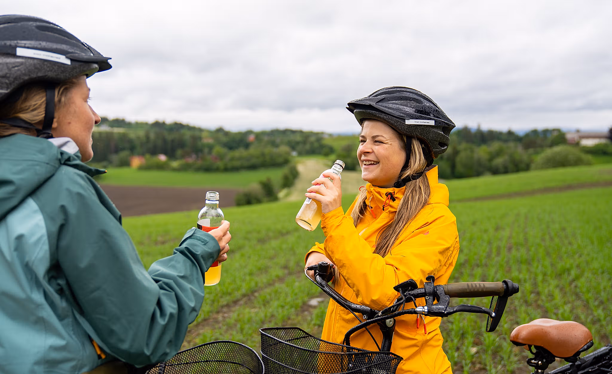 Two woman enjoying a juice from the bicycle seat